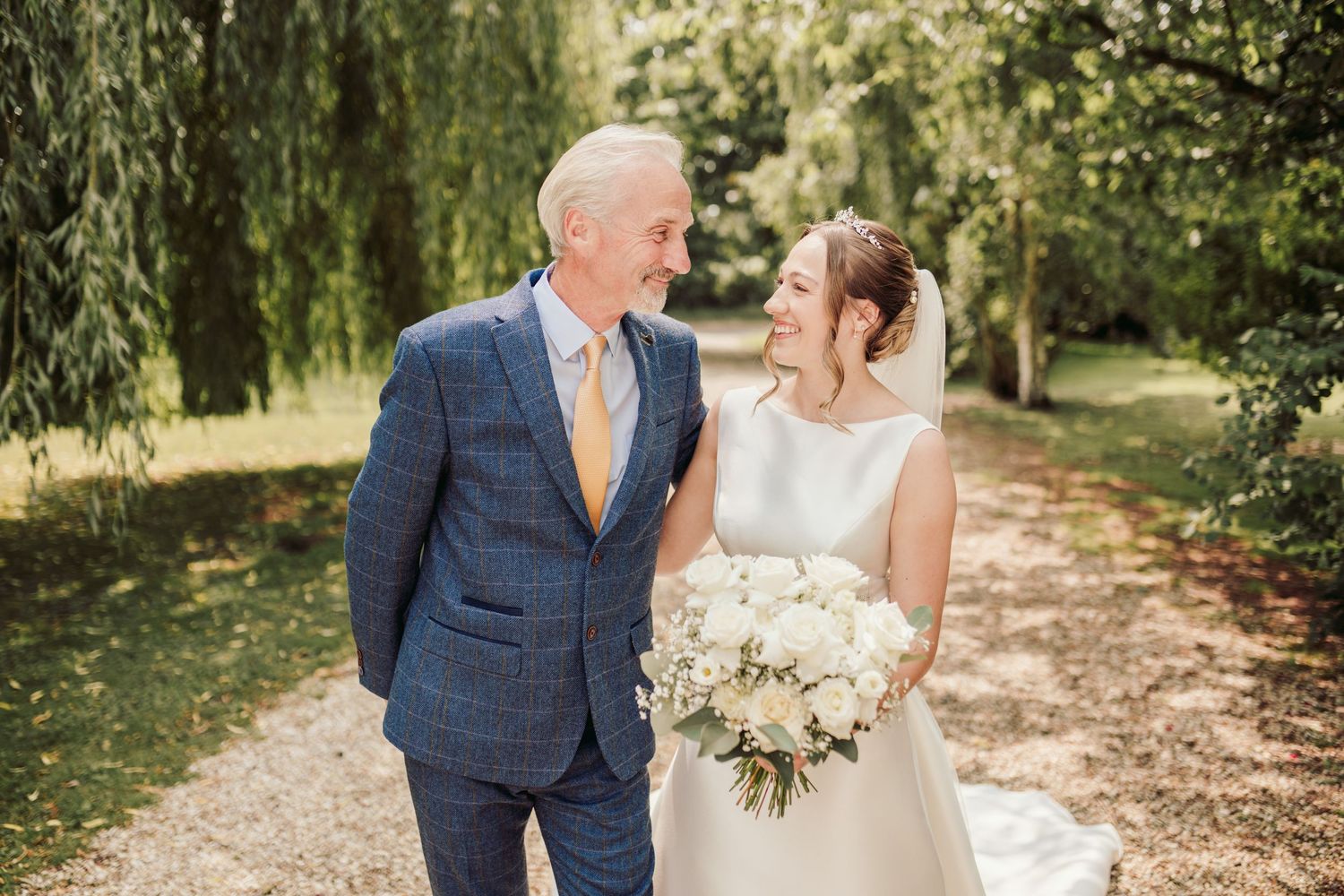 A bride and groom share intimate moments during their outdoor woodland wedding photoshoot.
