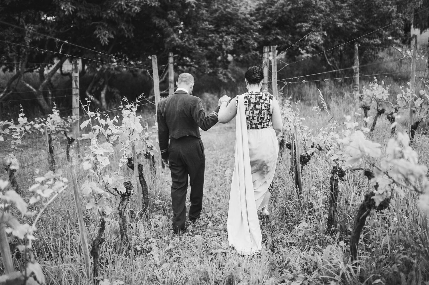 Two figures stand in a rustic garden filled with blooming iris flowers on a summer day, captured in black and white.Spiez switzerland