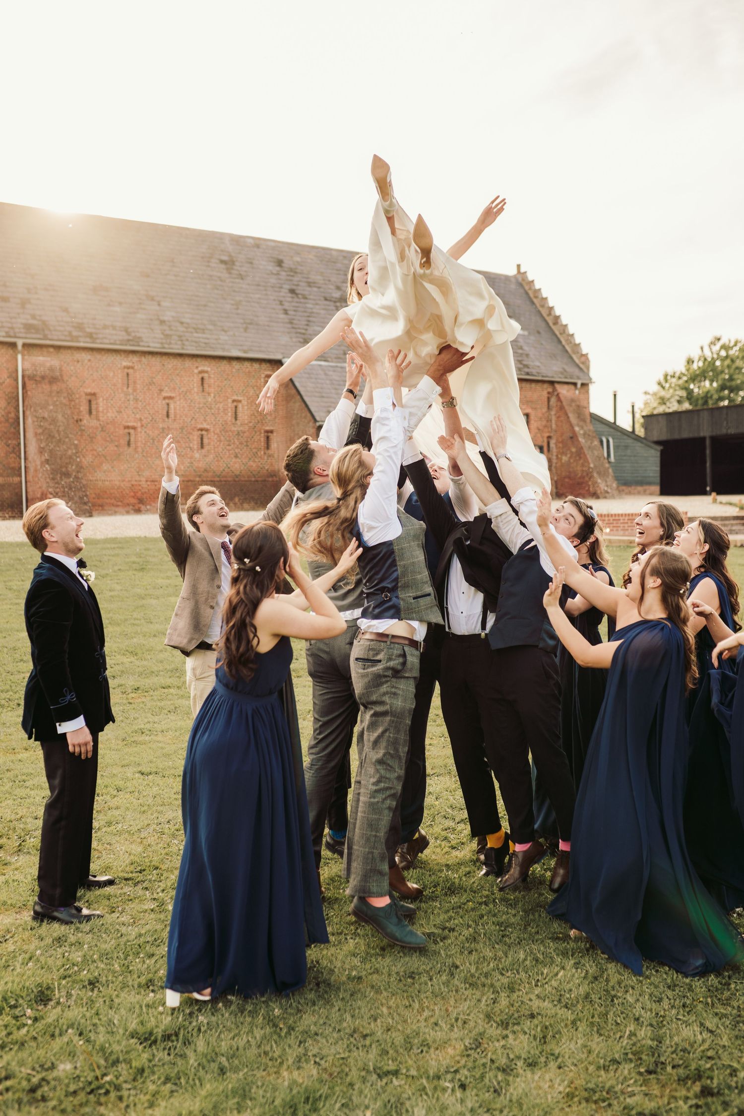 Wedding party in navy blue dresses and dark suits toss paper airplanes in sequence across four progressive photos.