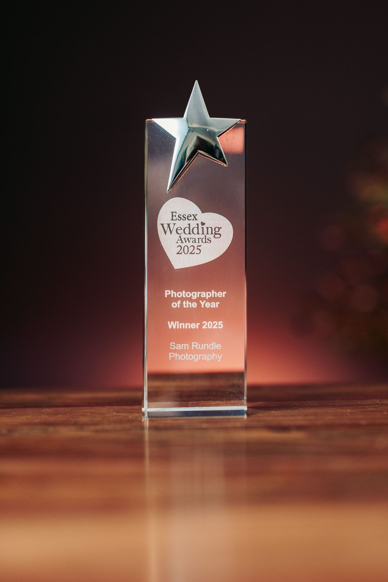 Crystal star award trophy displayed on wooden surface with dramatic lighting.