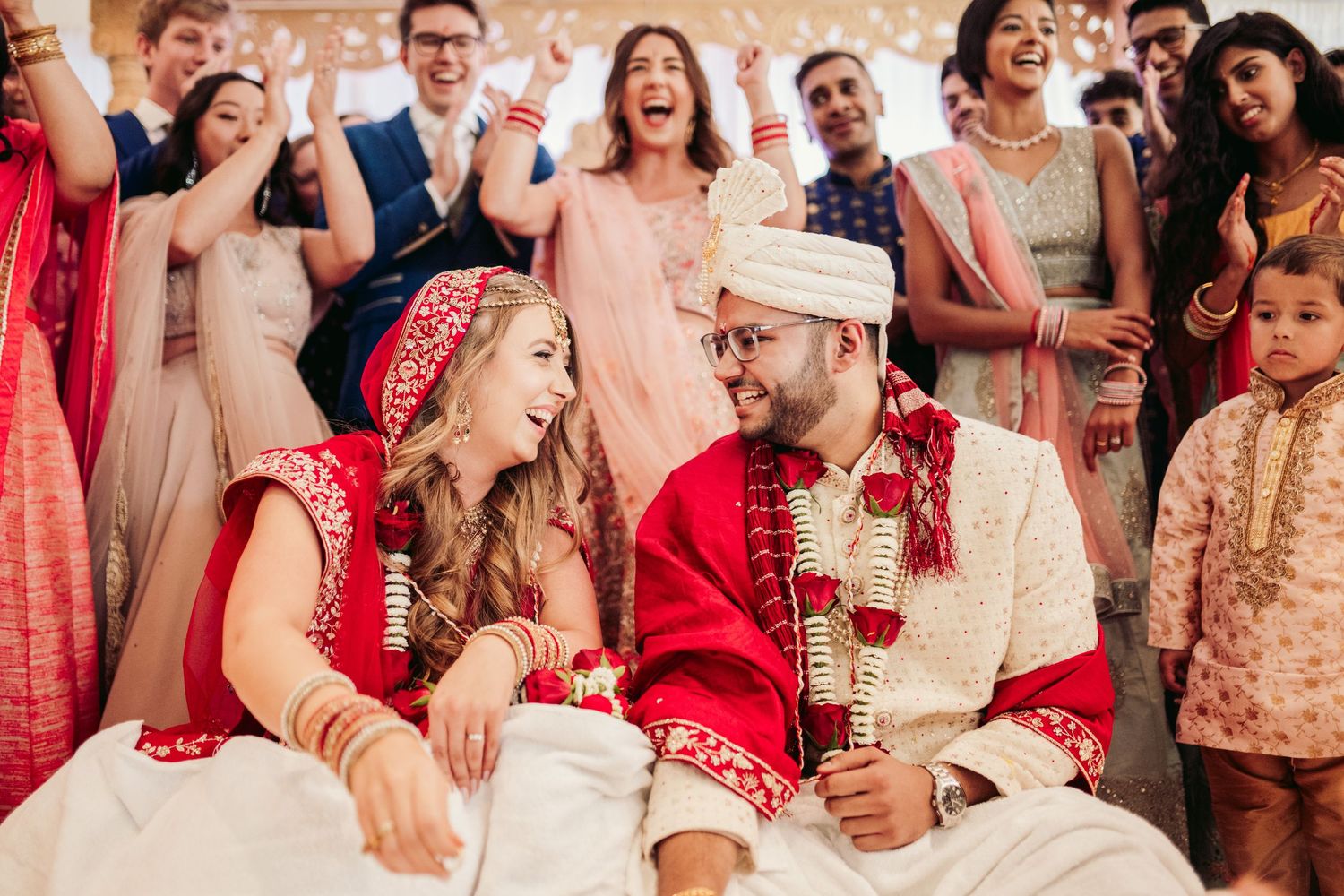 Wedding guests celebrate with joyful expressions during a festive reception.