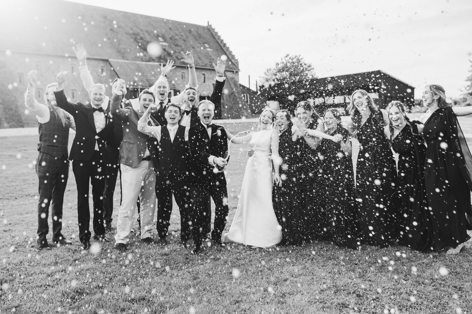 A sequence of black and white wedding photos showing a group celebrating outdoors in falling snow.