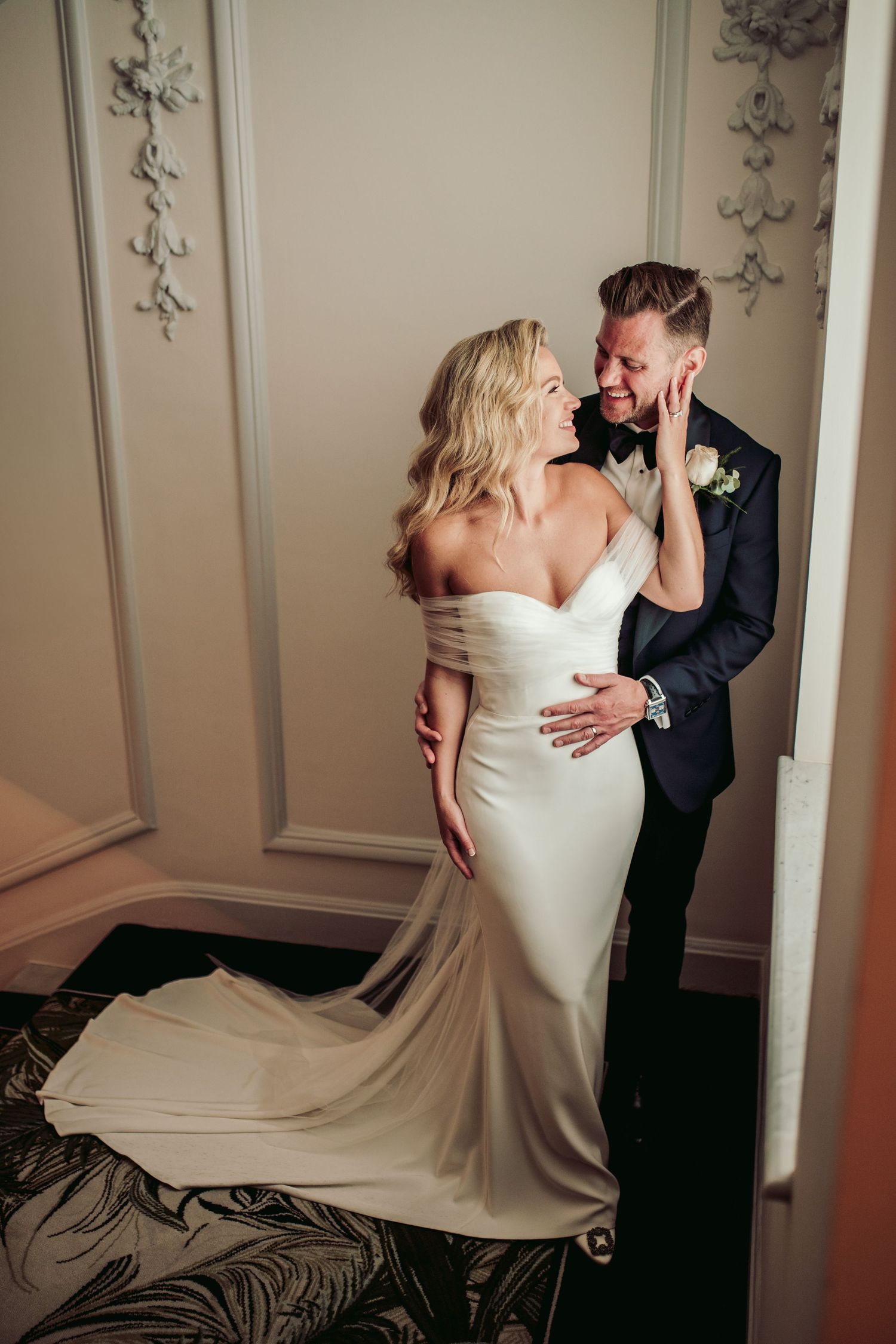 Elegant wedding portraits in classic interior with ornate wall details and flowing dress.