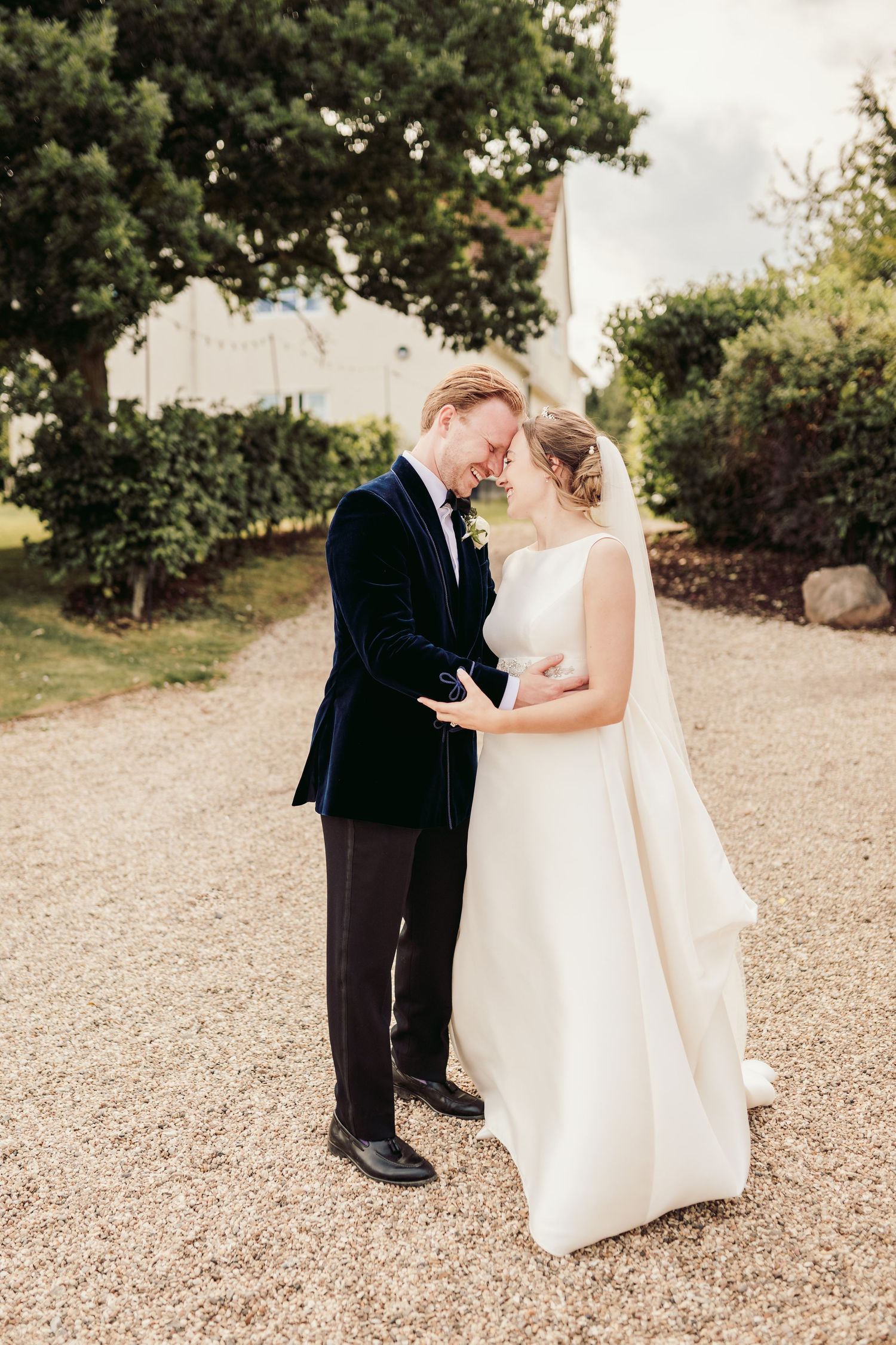 Intimate wedding portraits on a gravel path surrounded by greenery.
