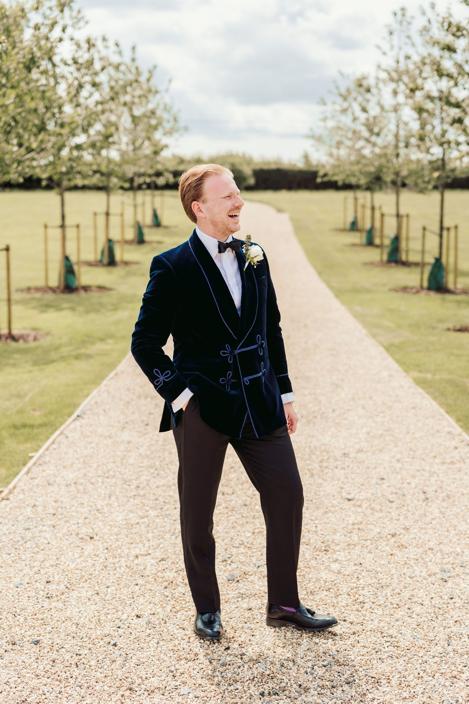 A sequence of photos showing a person in a dark suit walking playfully along a gravel path lined with young trees.