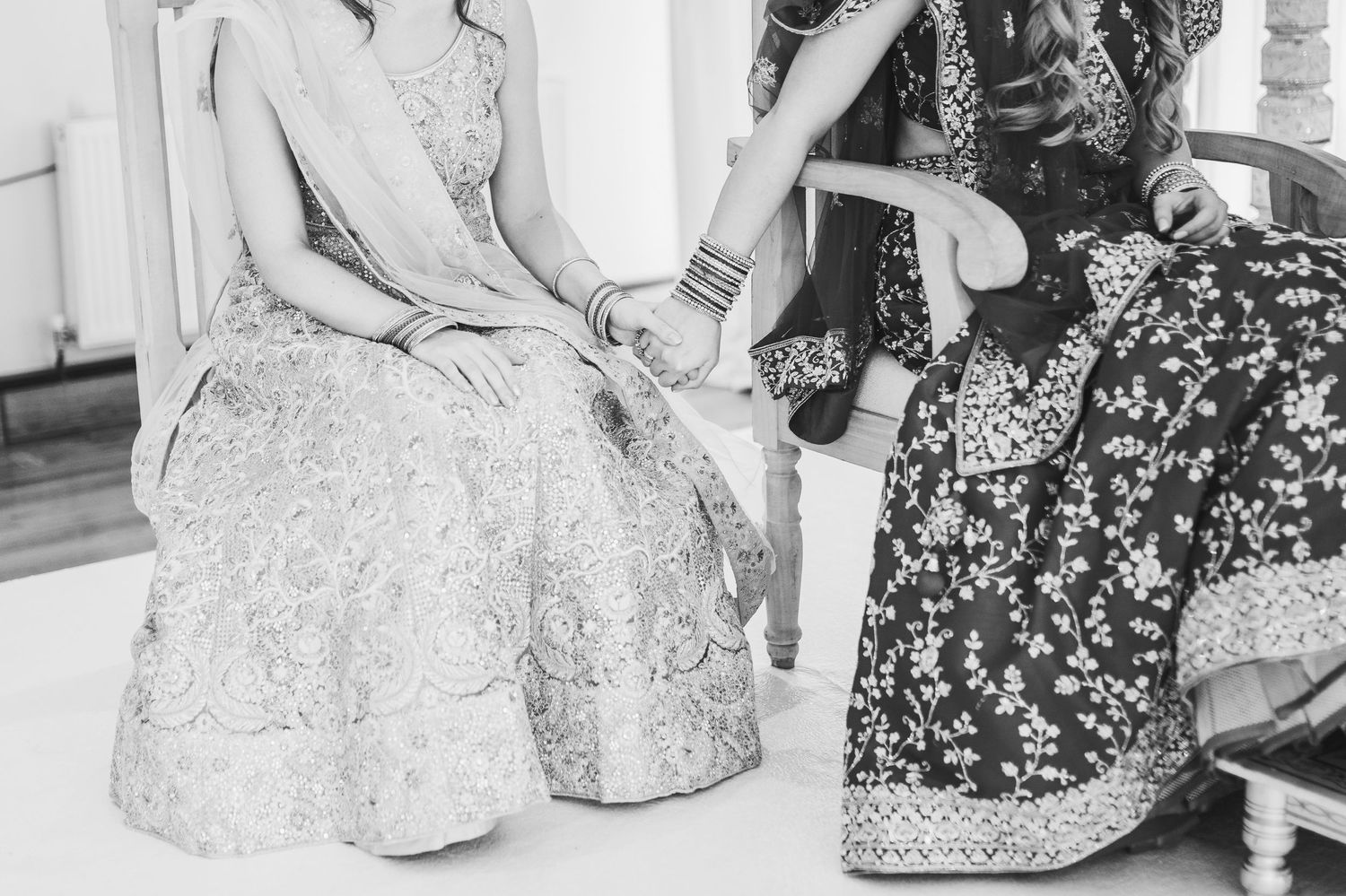 Vintage black and white photograph showing seated figures in formal dresses during a social gathering.