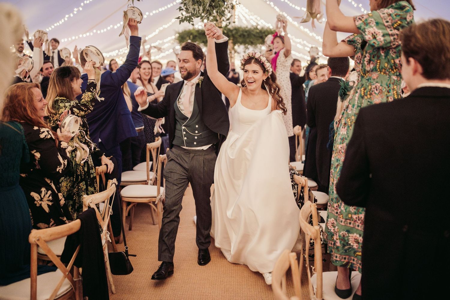 Wedding party dances and celebrates during evening reception indoors.