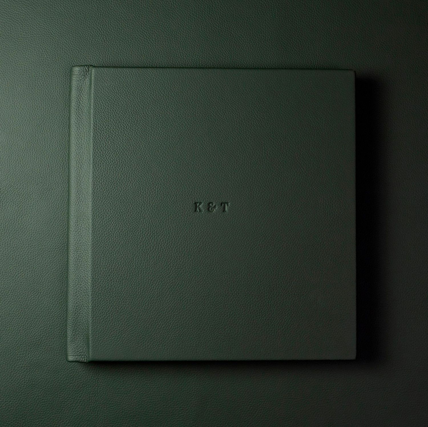 Elegant dark green photo album cover with subtle text detail.