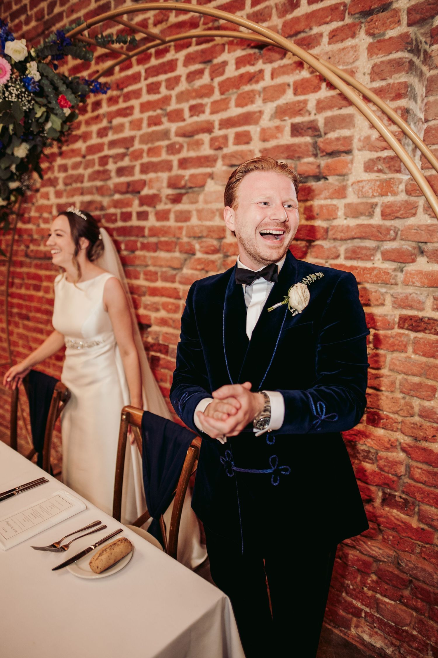 A sequence of candid moments at a wedding reception showing laughter and joy against a rustic brick wall backdrop.