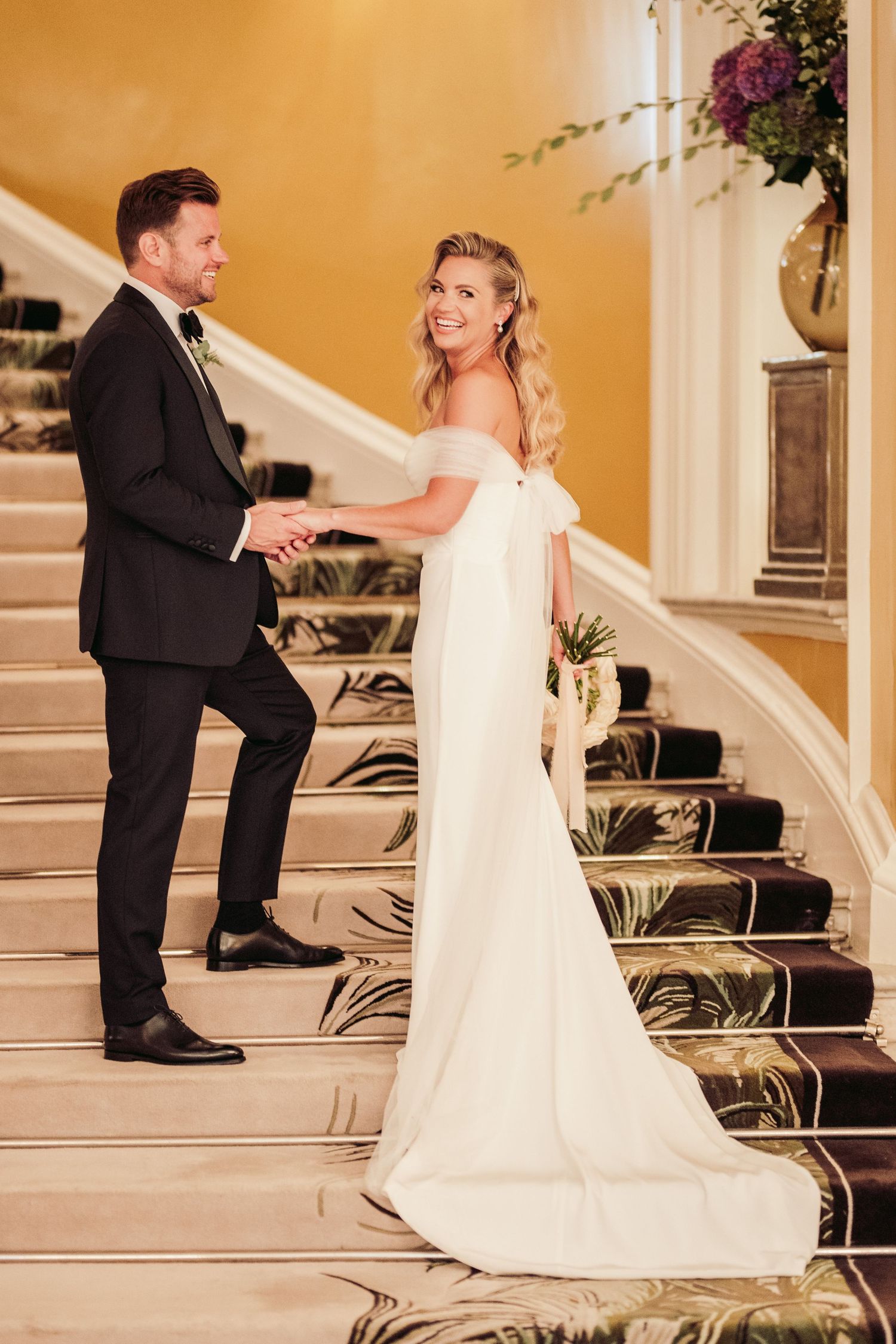 Romantic couple dancing on an elegant staircase during their wedding celebration.