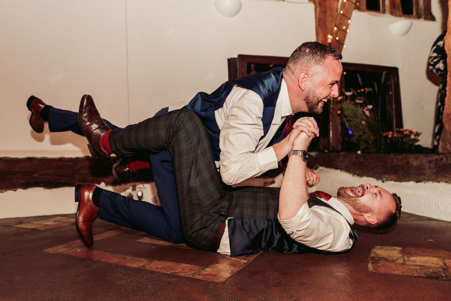 Guests performing dramatic dance moves on the floor during a wedding reception.