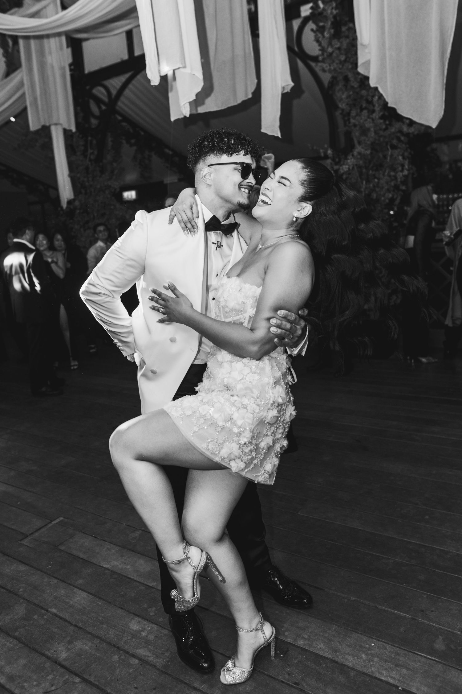 Couple shares intimate dance pose in black and white photography.