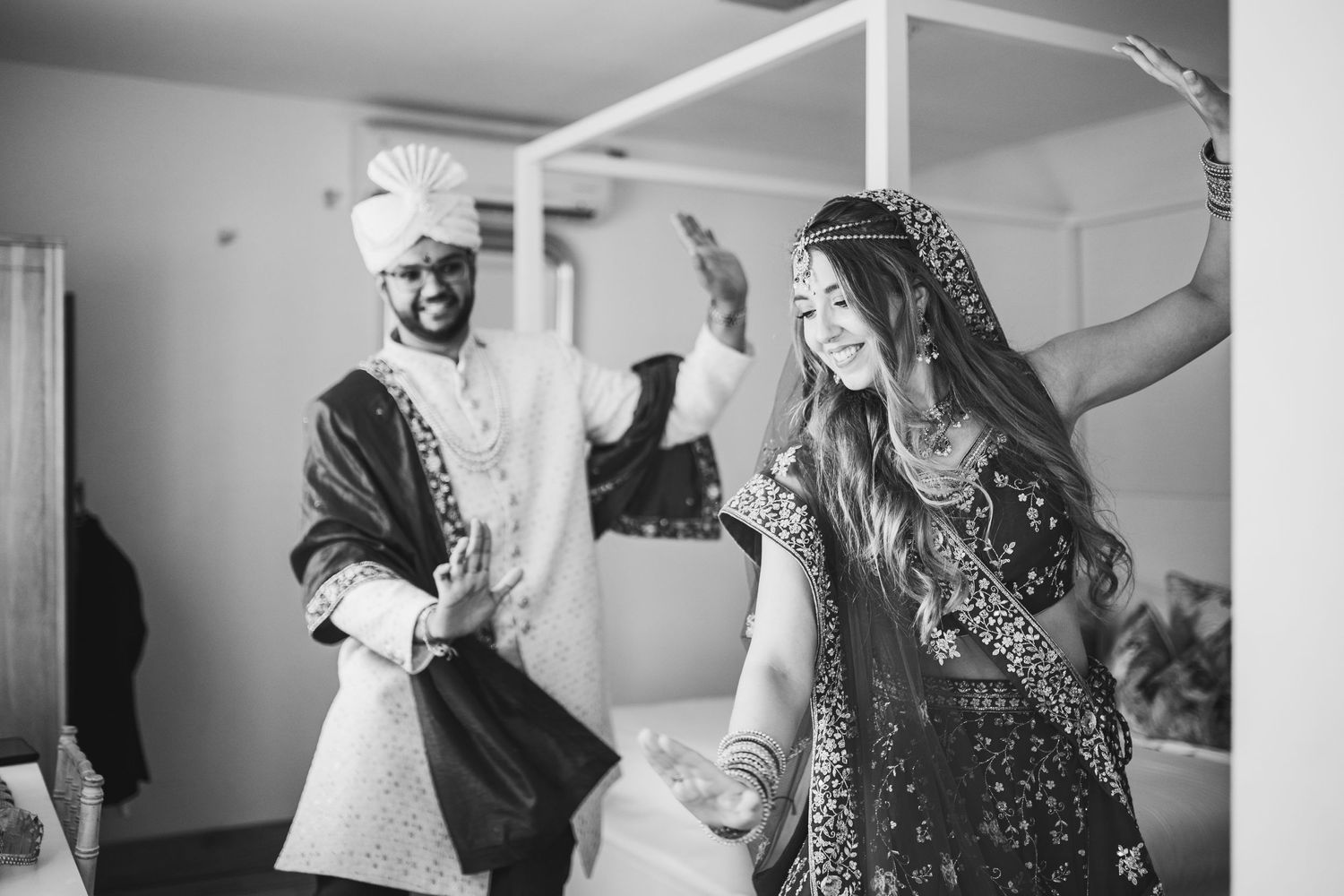 A black and white photograph of a couple dancing and celebrating at an elegant wedding celebration.