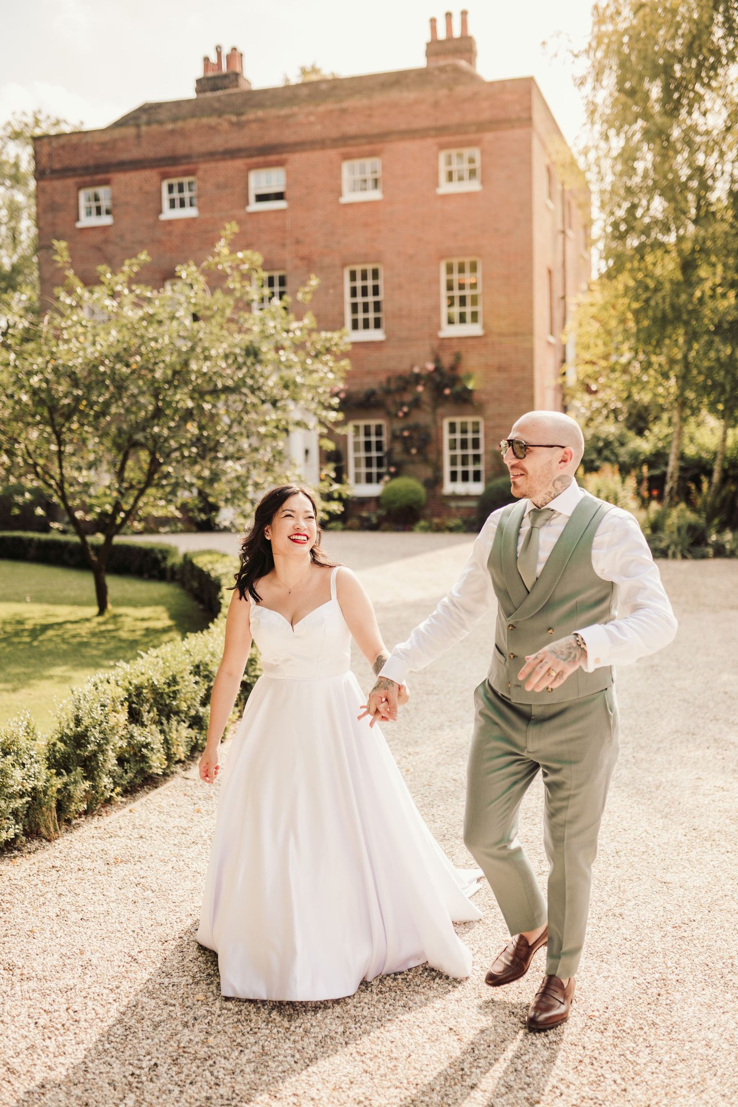 Joyful moments captured on a gravel path outside a historic brick building.