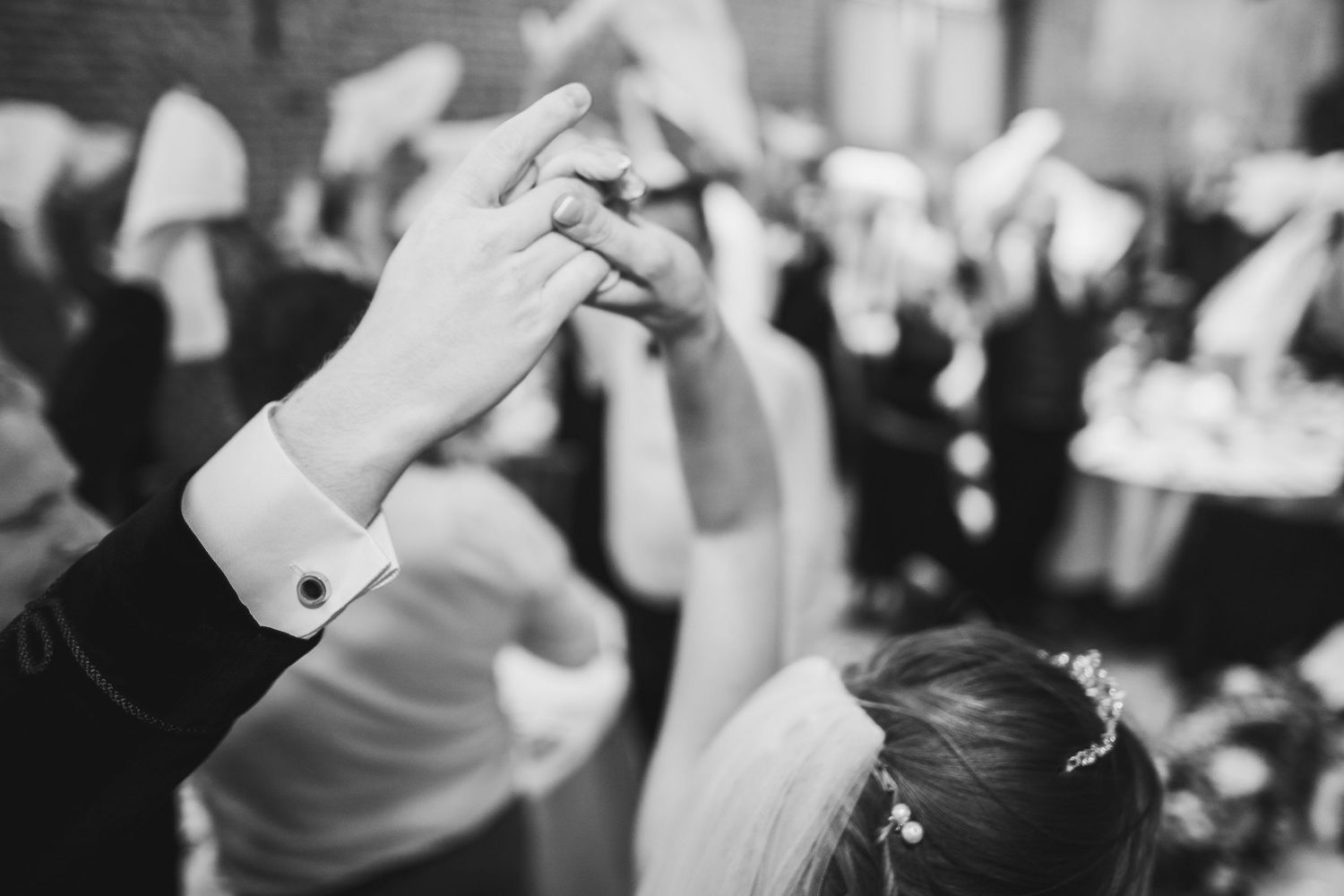 A black and white photograph shows a couple dancing at what appears to be a wedding reception or formal event.