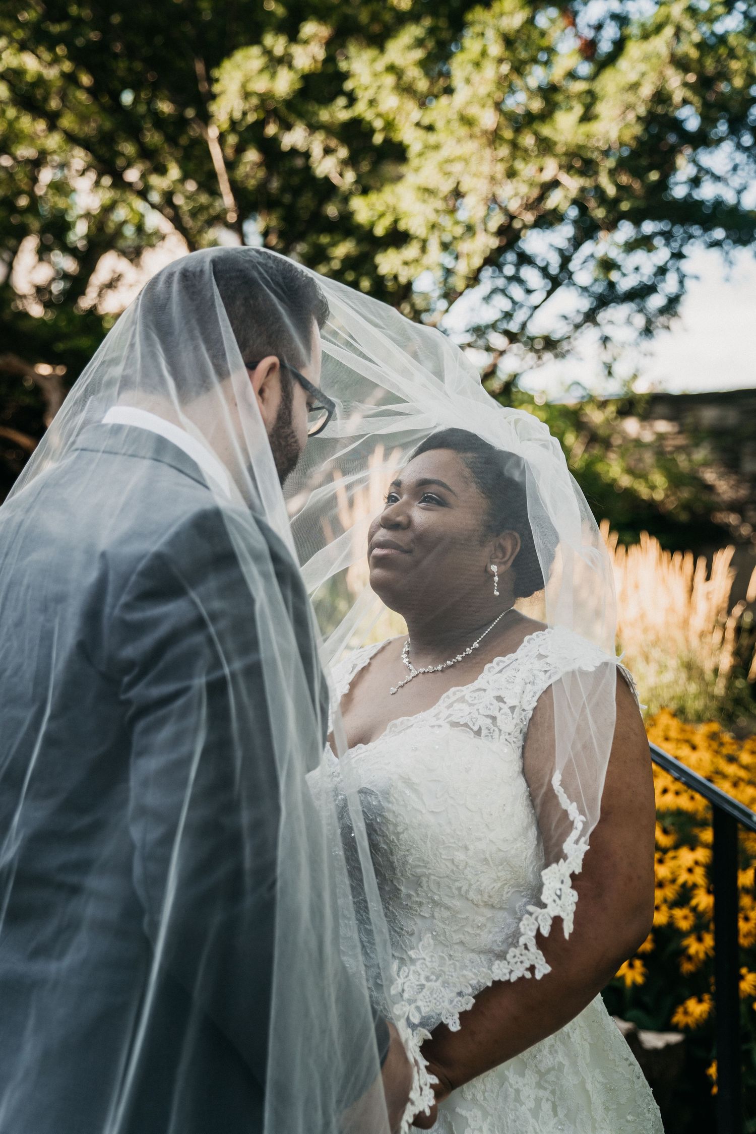 A newlywed couple shares an intimate moment beneath the Bride's veil at the Old Mill, Toronto.