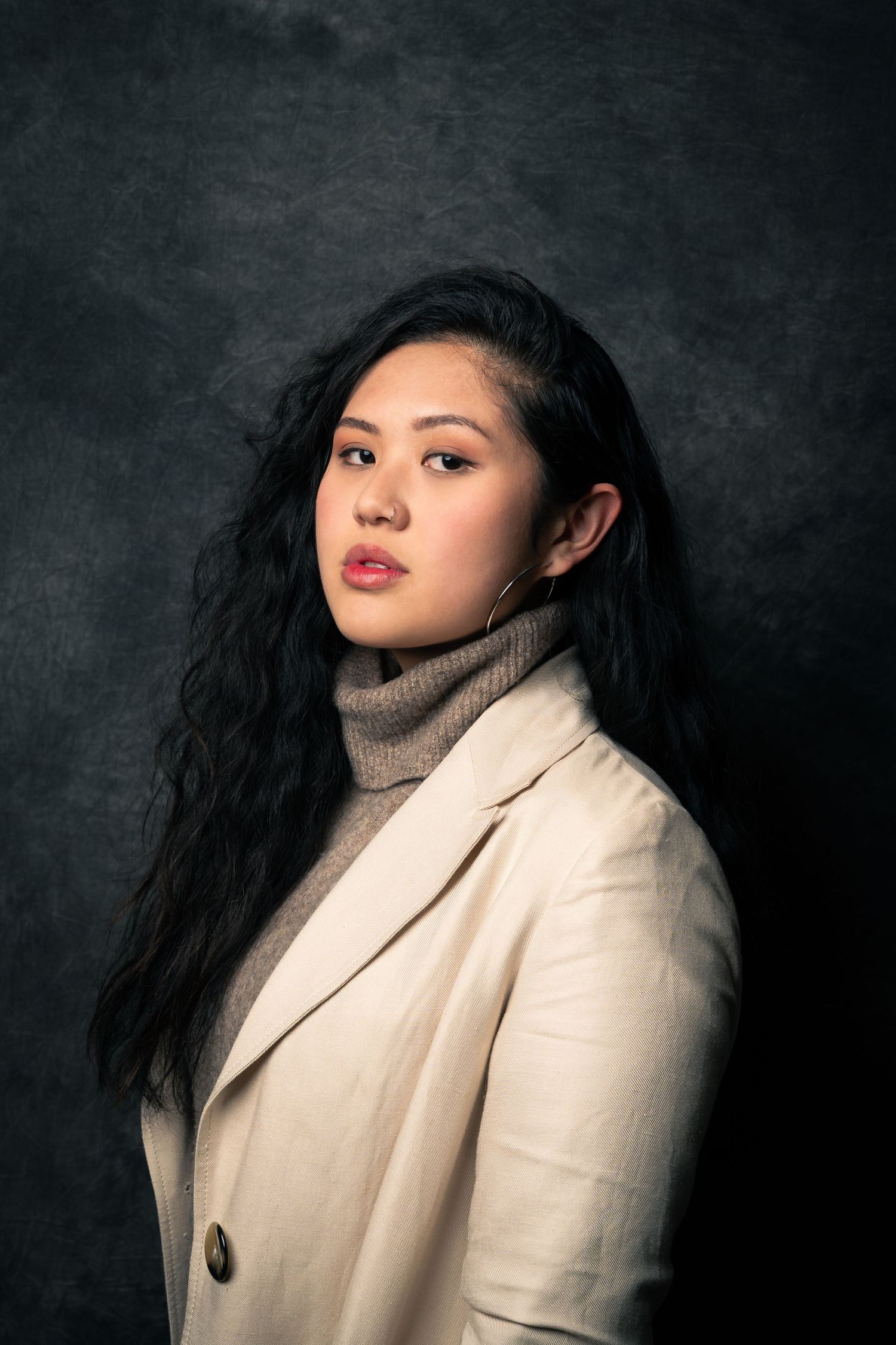 In-studio portrait of a dark-haired woman with heavy dramatic artificial lighting
