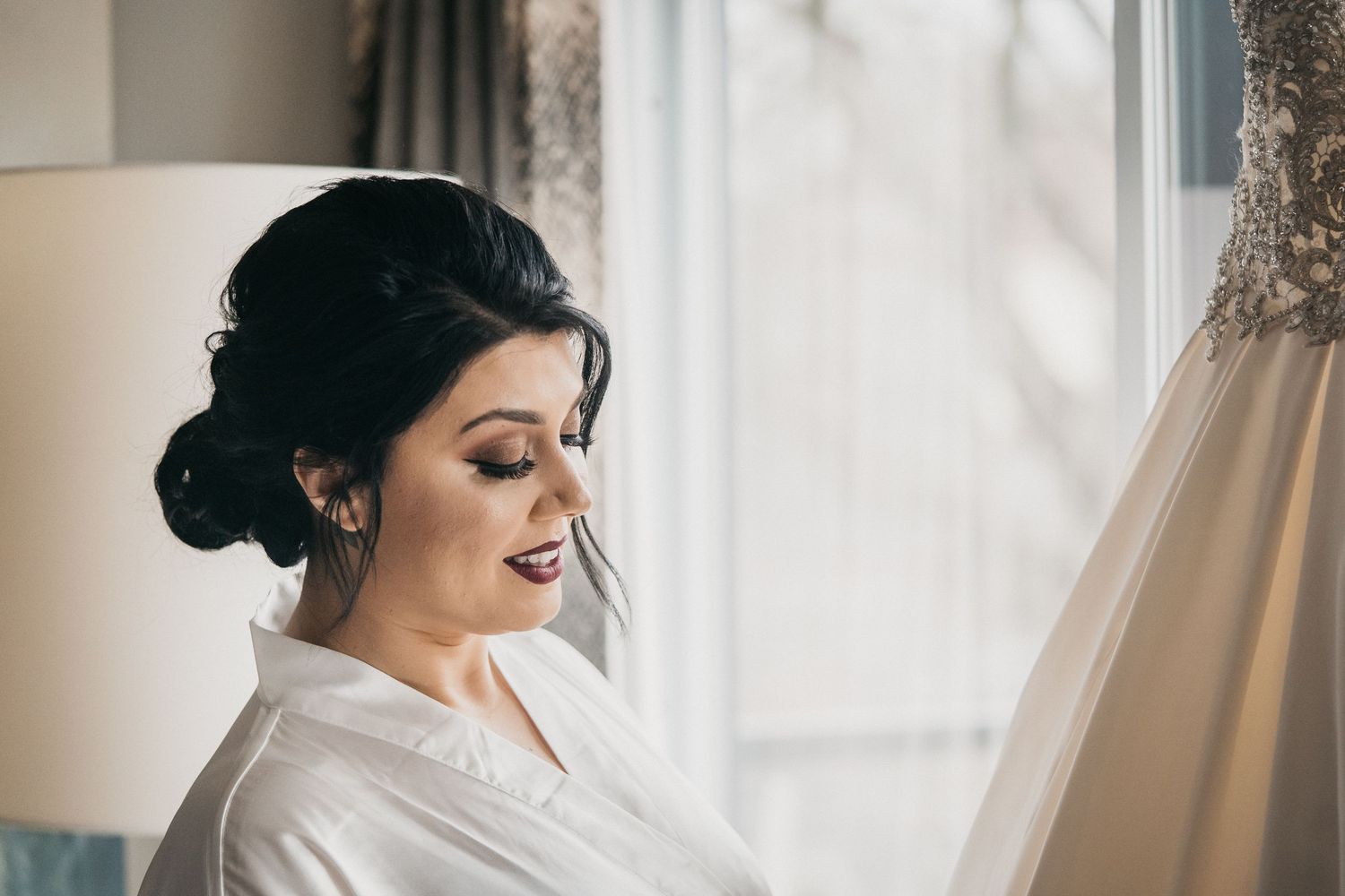 Bride admires her dress while preparing for her wedding day