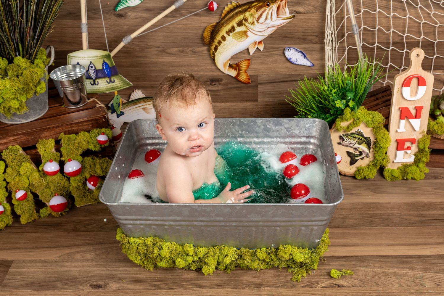 Baby's first birthday cake smash in fishing theme with galvanized tub, bobbers, and ONE sign.