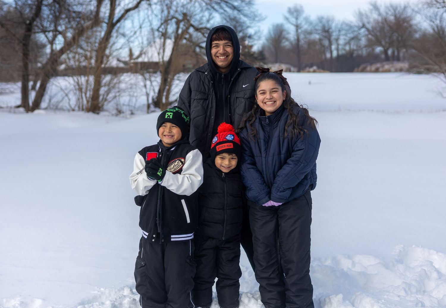 People enjoying a winter day in the snow, bundled up in warm coats and winter gear.