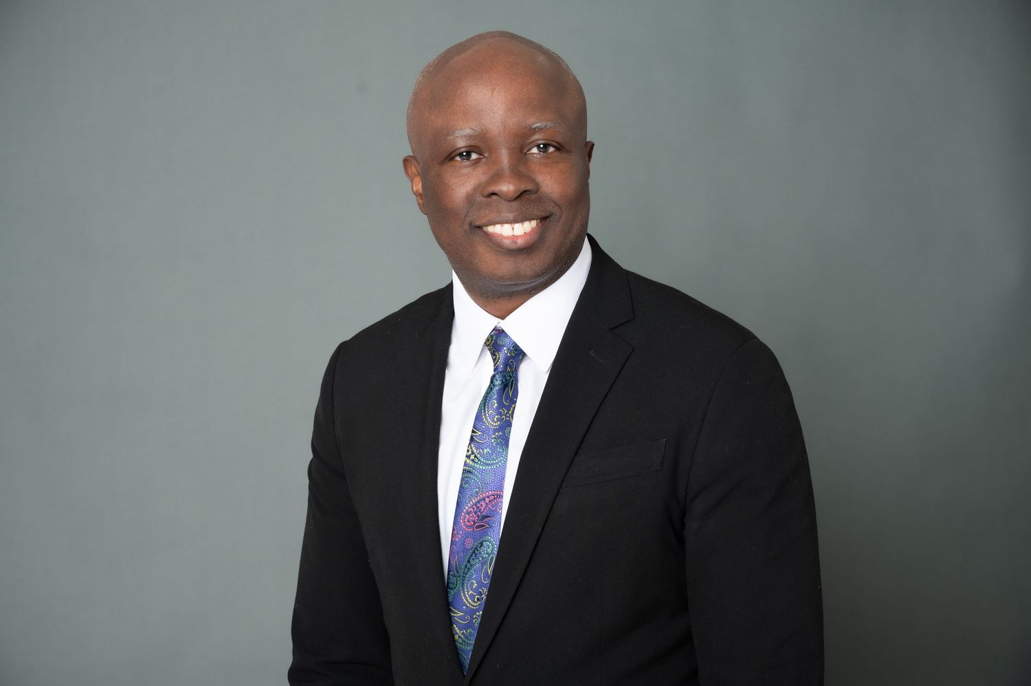 Business portrait series showing professional poses in suit and tie against gray backdrop.