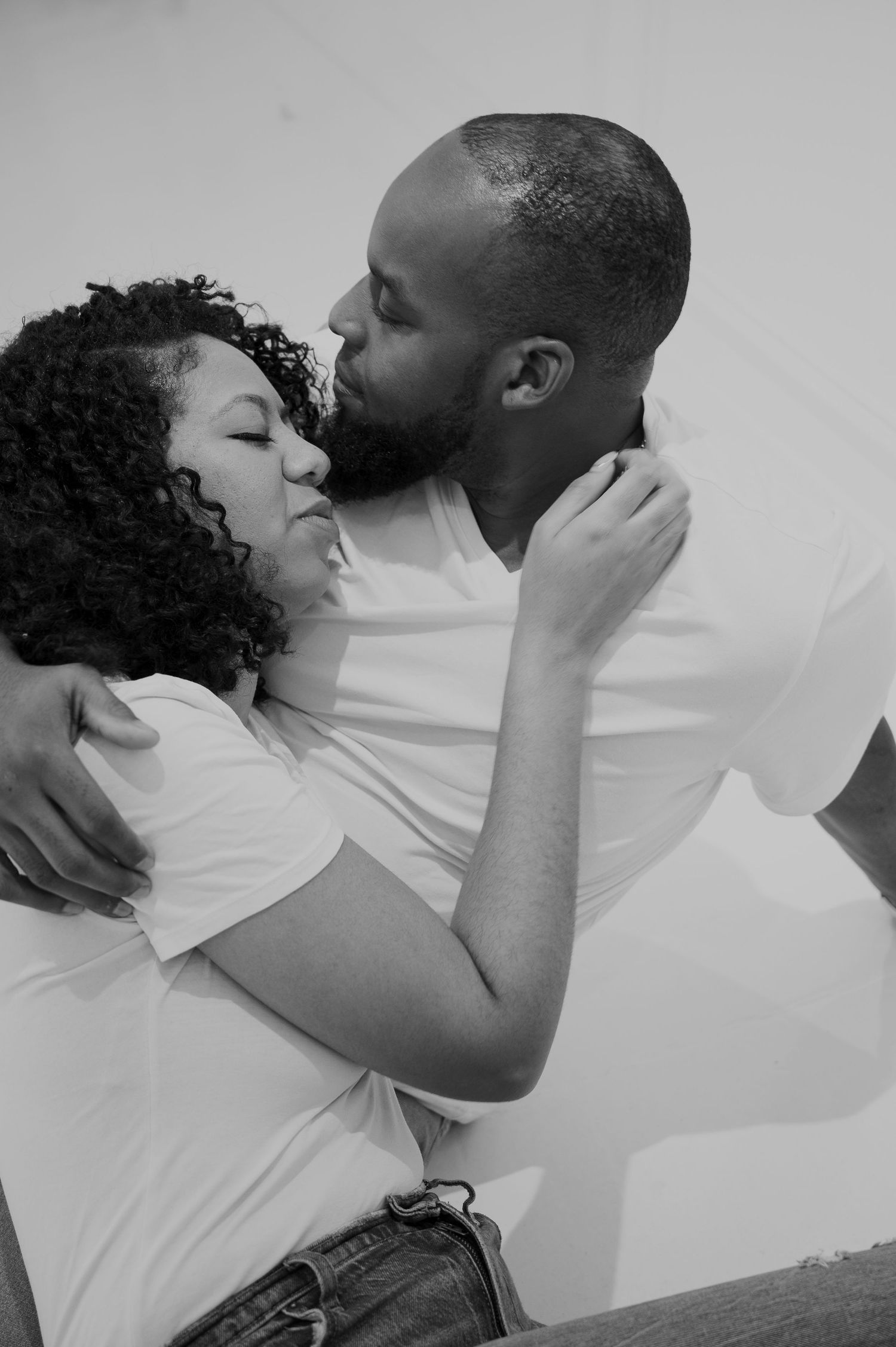 An intimate black and white photo sequence showing a tender embrace.