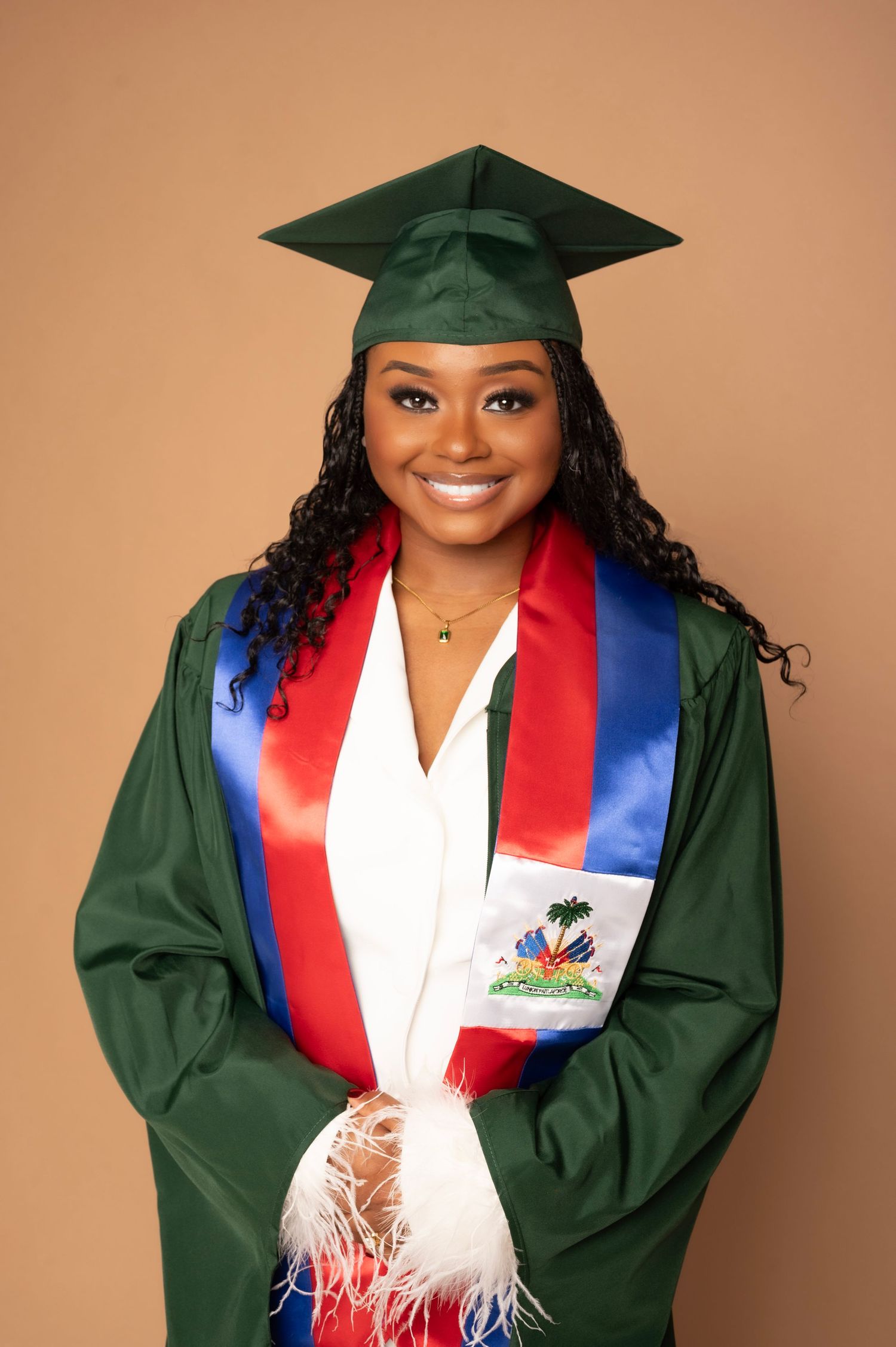 Graduation photos with someone wearing green cap and gown with Haiti flag sash.