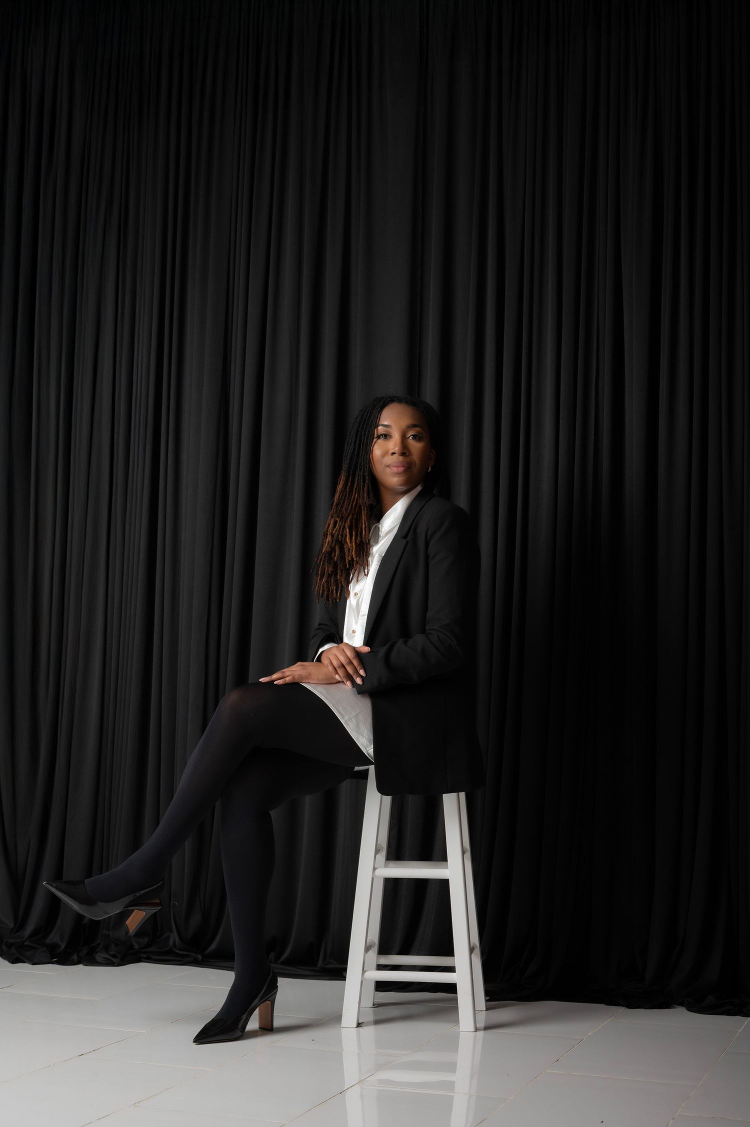 Artistic black and white studio portraits with dramatic lighting and white chair.