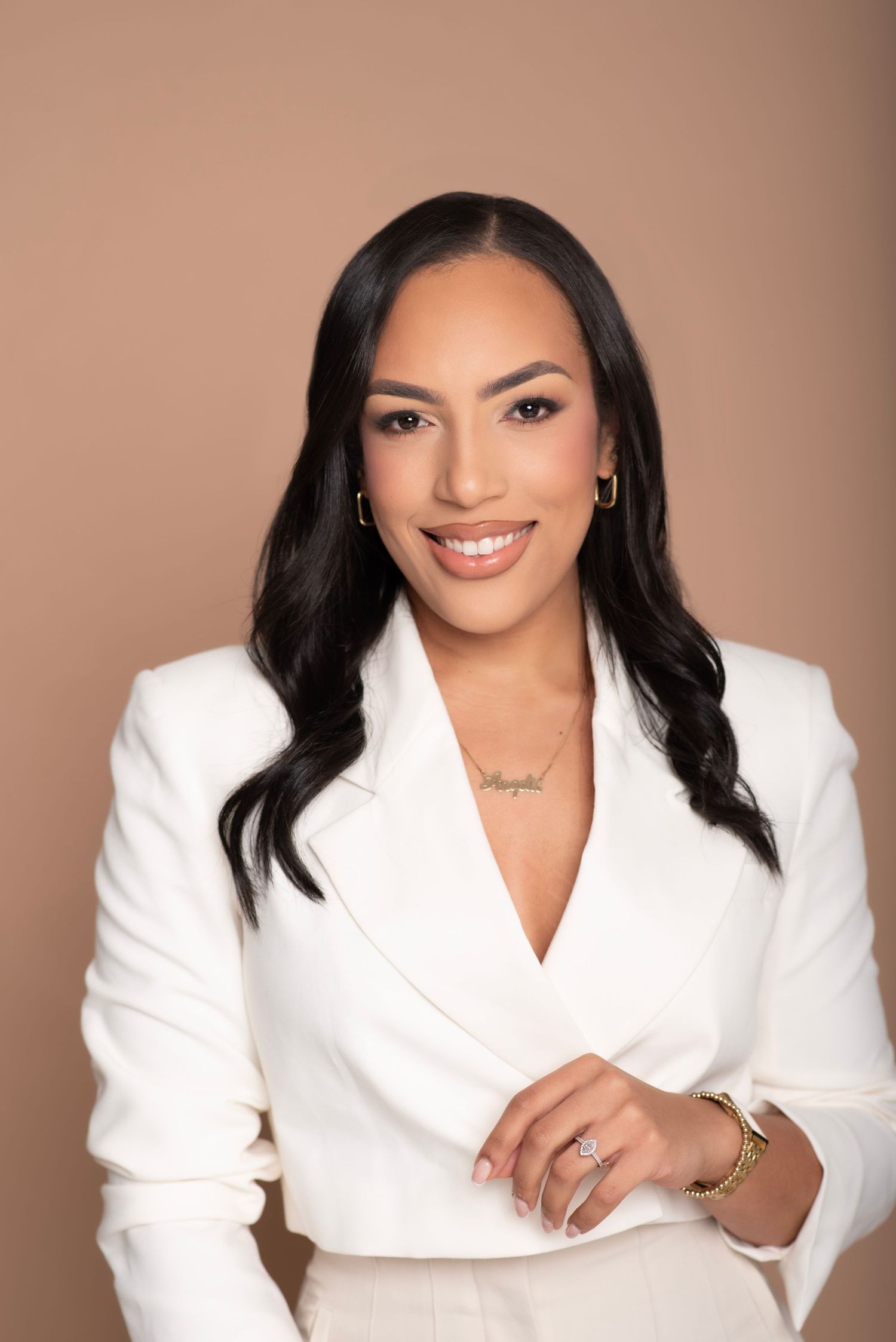 Professional portrait series in white blazer against warm brown background showing various poses.