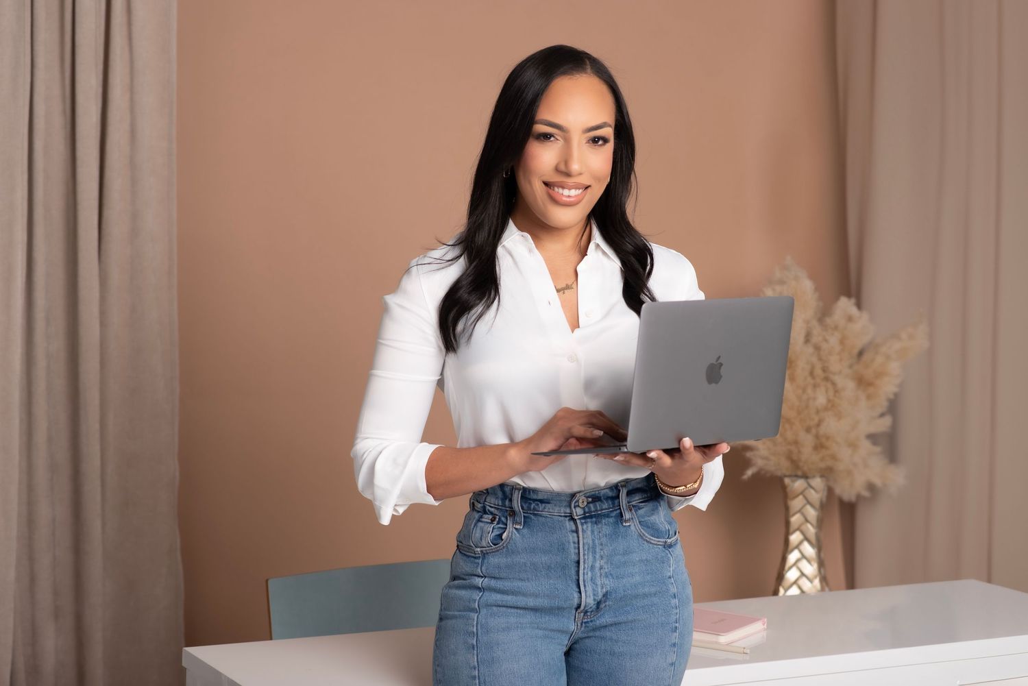 Professional business photoshoot in a modern office setting with laptop and casual attire.