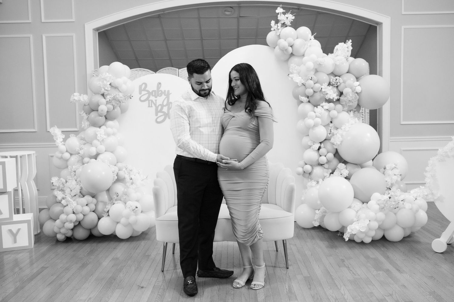 Elegant wedding photoshoot with white balloon arch decorations and architectural details with couple standing in the middle.
