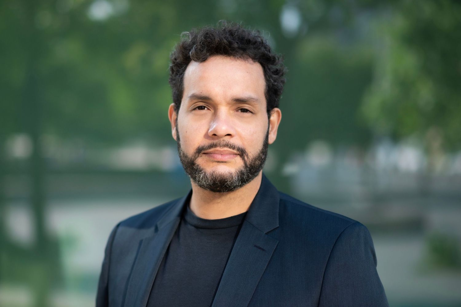 Professional headshots showing a person in business attire against a green outdoor background.