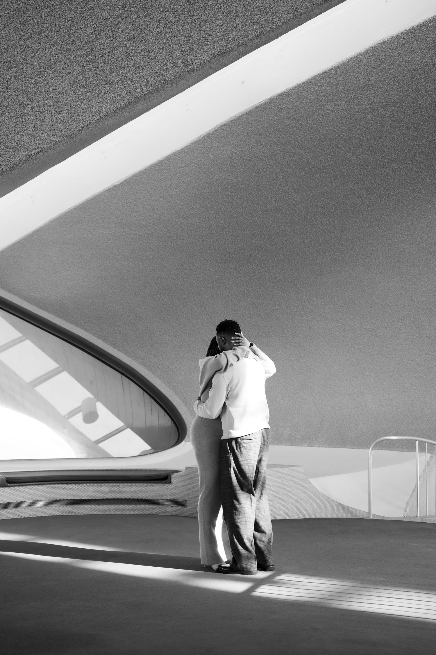 Minimalist architectural series showing curved white walls and dramatic shadows. Couple dancing during engagement shoot