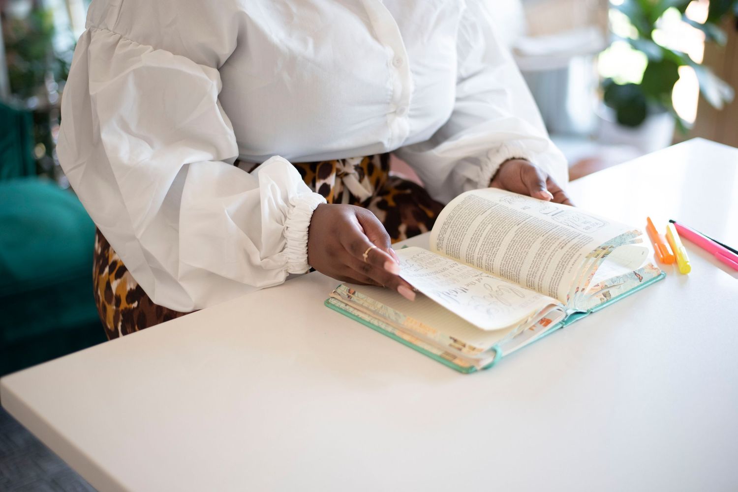 Healthcare professional reviewing medical records and documents at a desk with natural lighting.