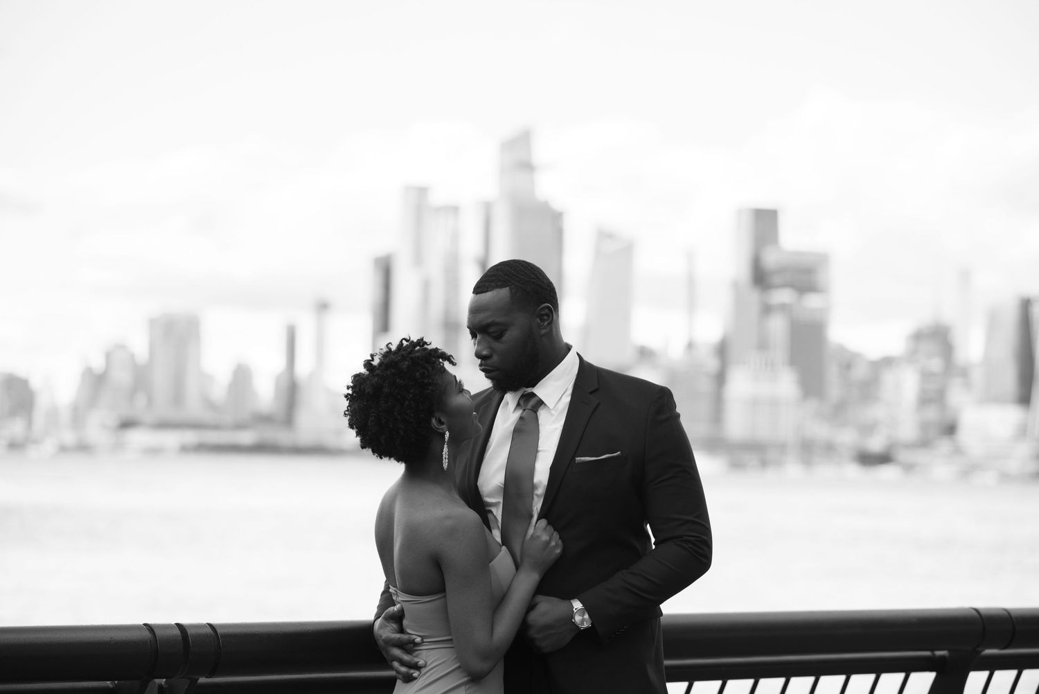 Wedding couple embracing with city skyline in background.