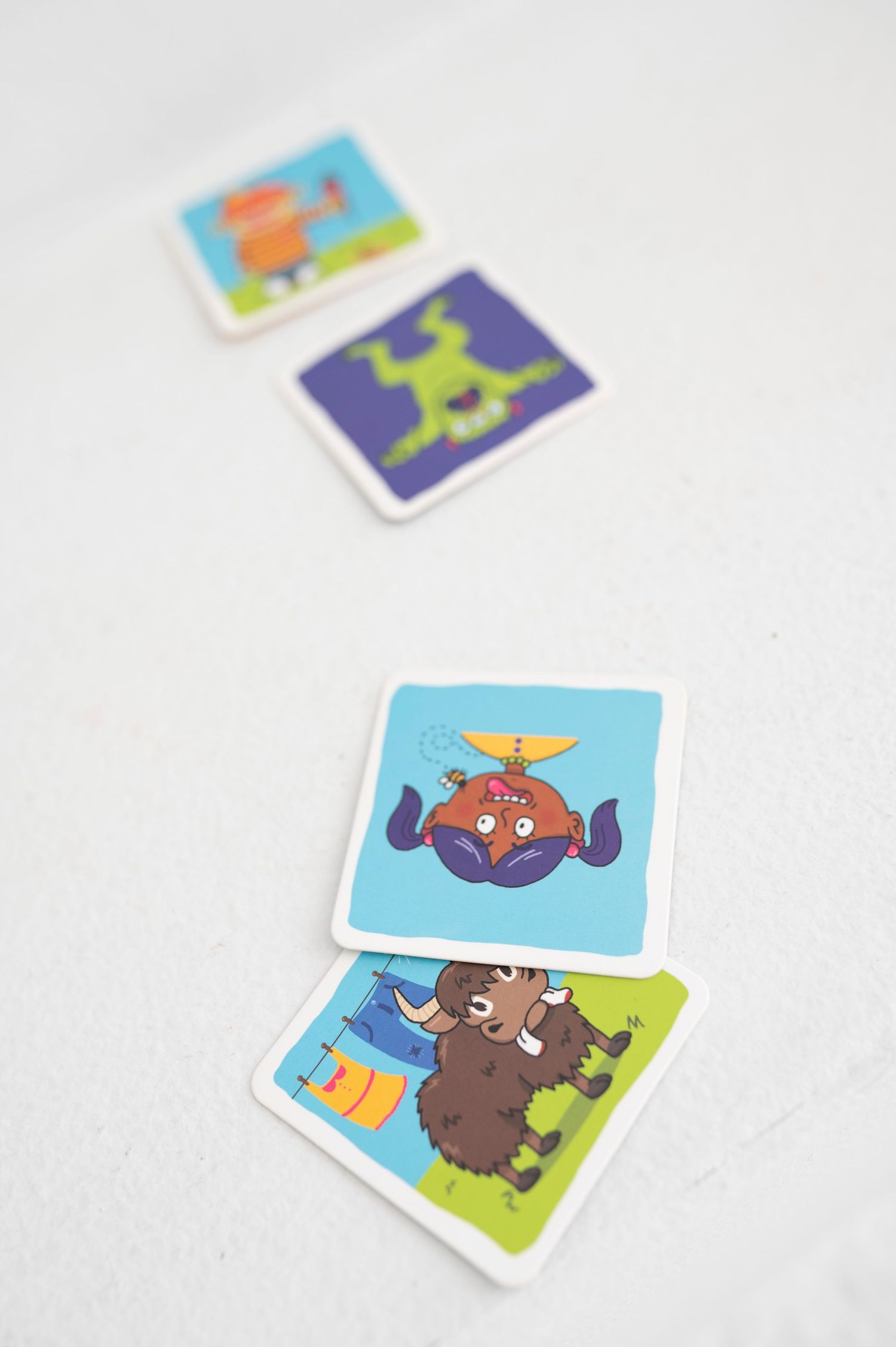 Colorful cartoon animal flashcards scattered on a white surface.