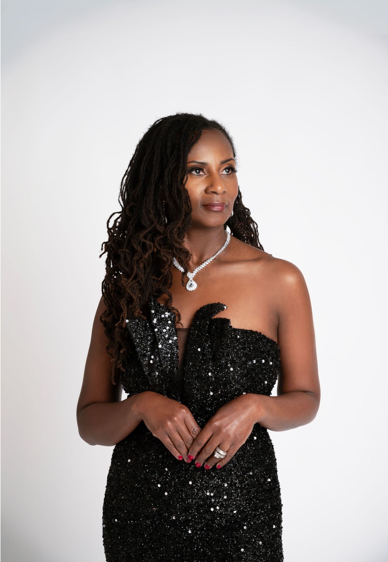 Glamour portraits in a sparkling black sequin dress against a white background.