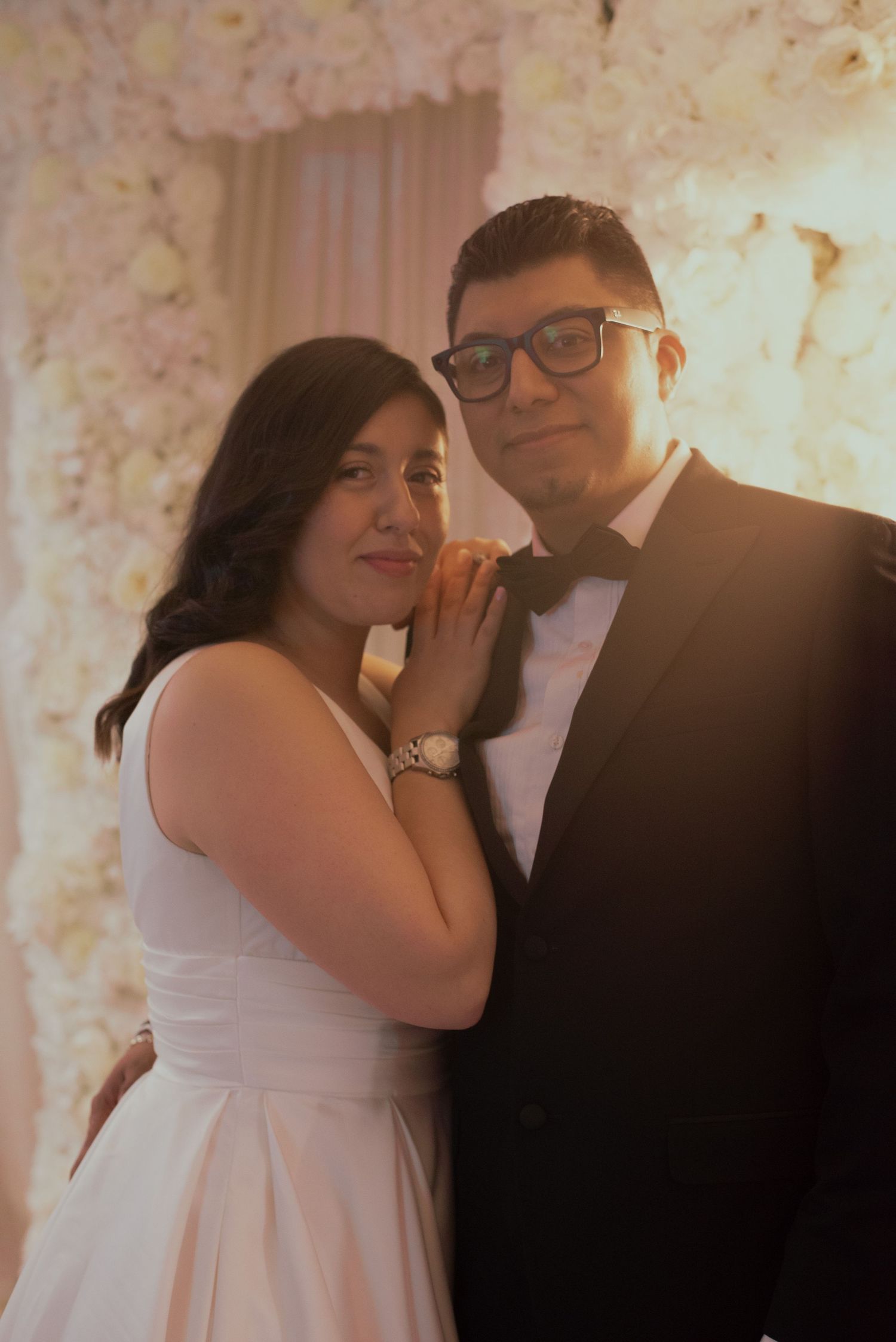 A romantic moment captured against a backdrop of white floral decorations.