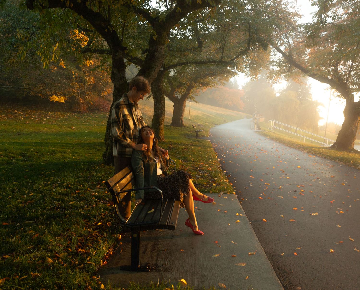 Black and white of couple outside, storytelling session,   woman sitting on a bench, looking up at man