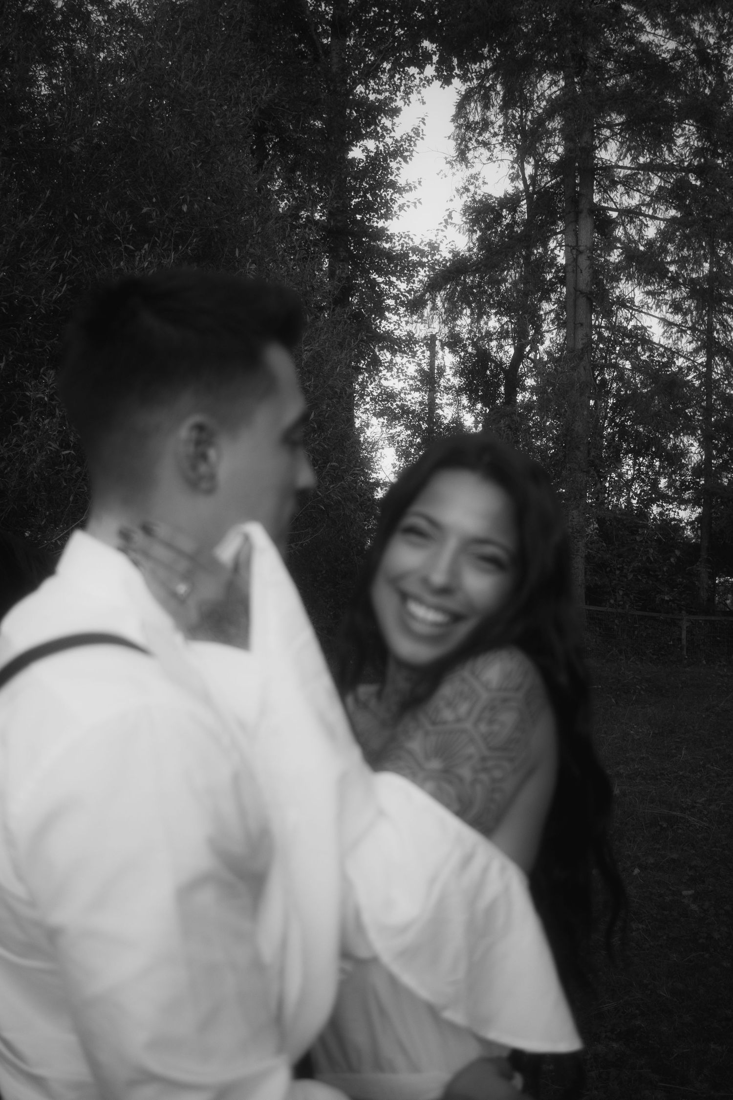 Couple at sunset, storytelling session, engagement session, black and white, woman smiling at camera, blurry grainy photo