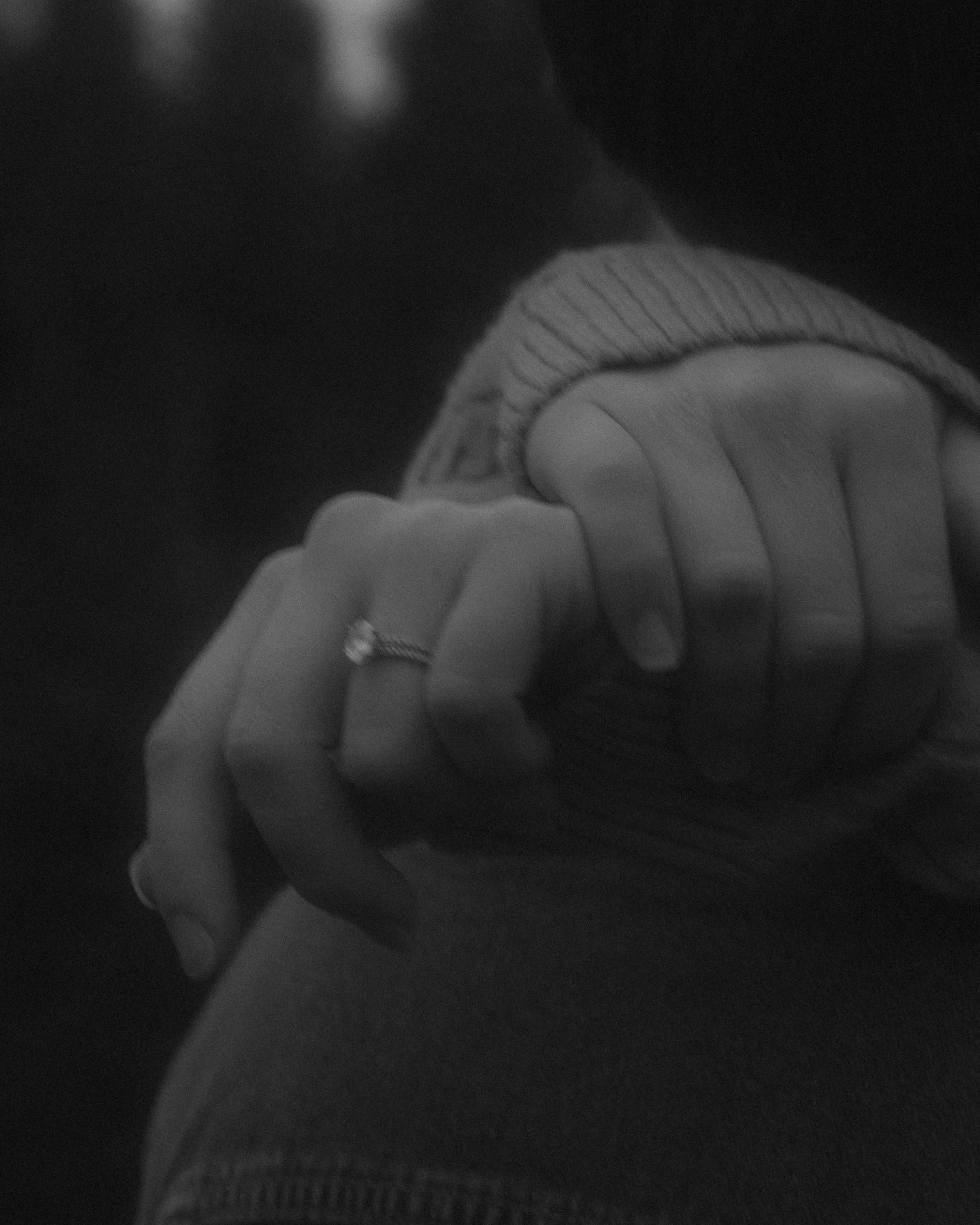 Black and photo photography, close up of woman's hands showing her wedding ring, grainy, film inspired
