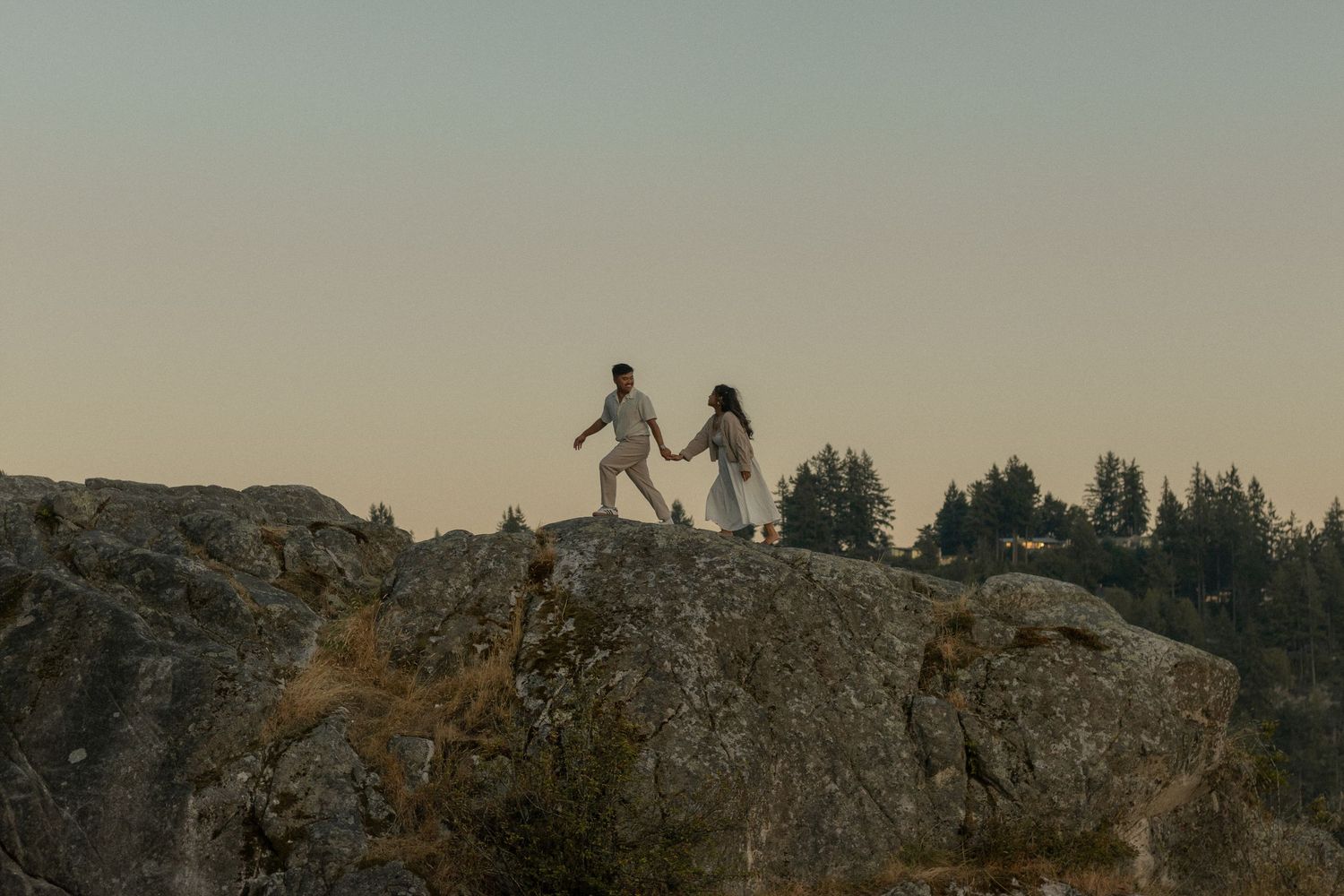 Engagement session, couple walking along a ridge holding hands