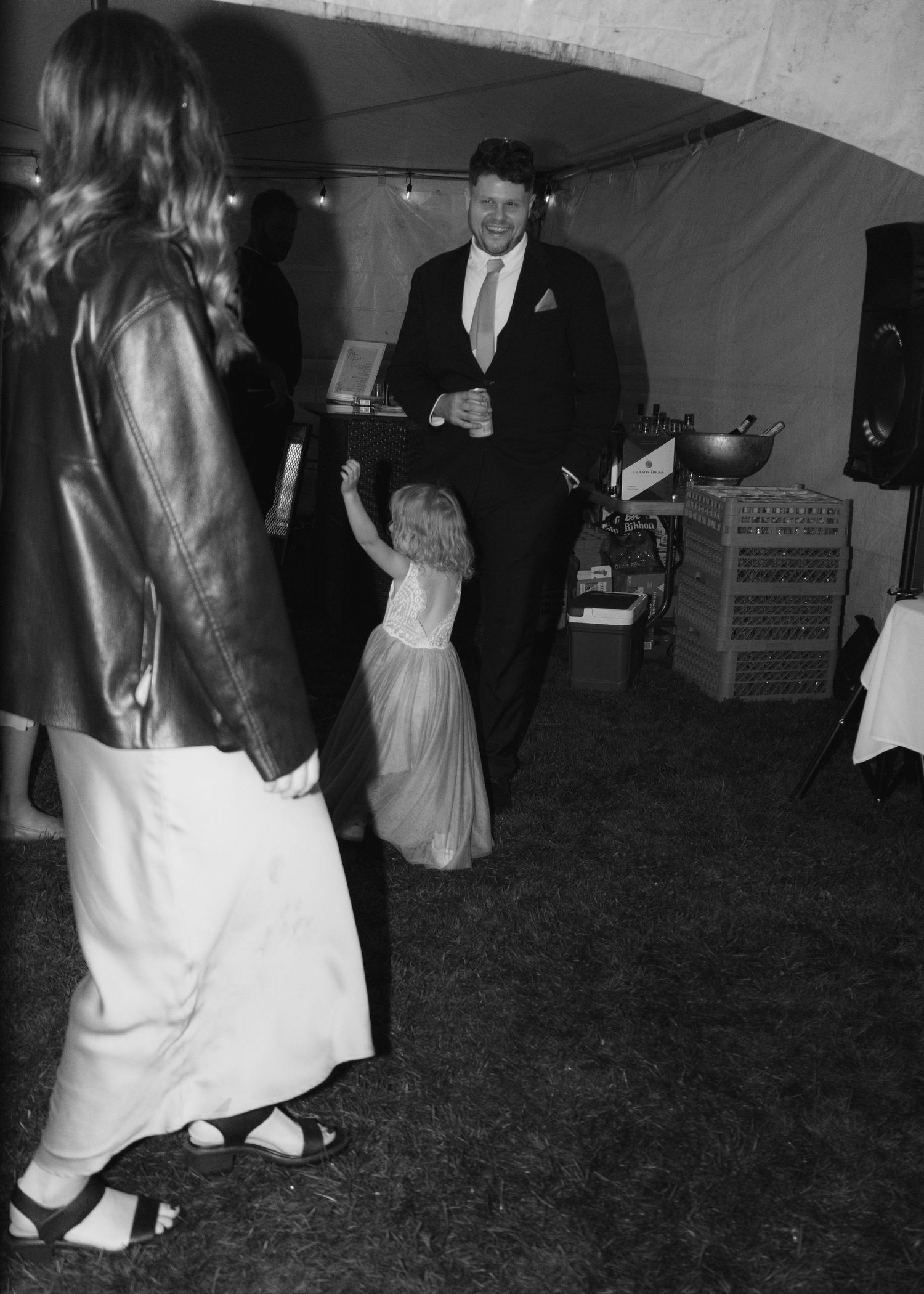 Black and white flash photo, children dancing in the crowd of a reception