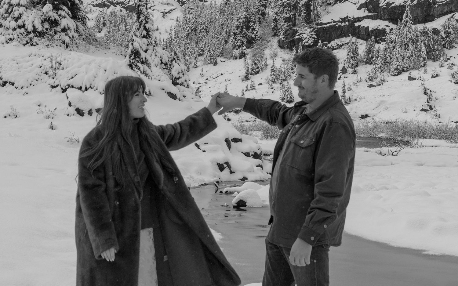 Black and white photo, couple dancing together in the snow, intentional grain, film inspired, BC engagement photographer