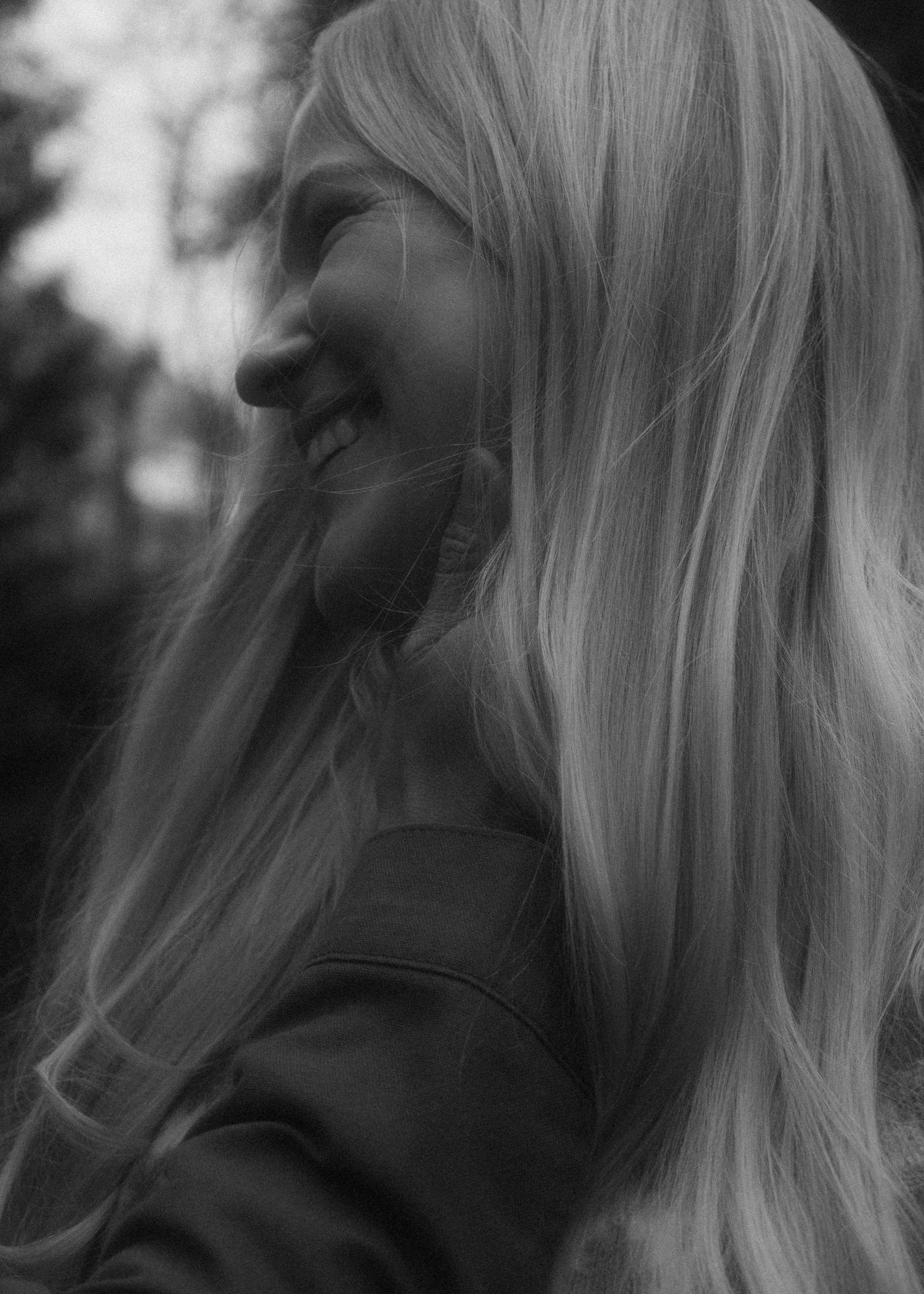 Woman's smiling face as her husband holds her cheek. Black and white photo, cinematic, intentional blur