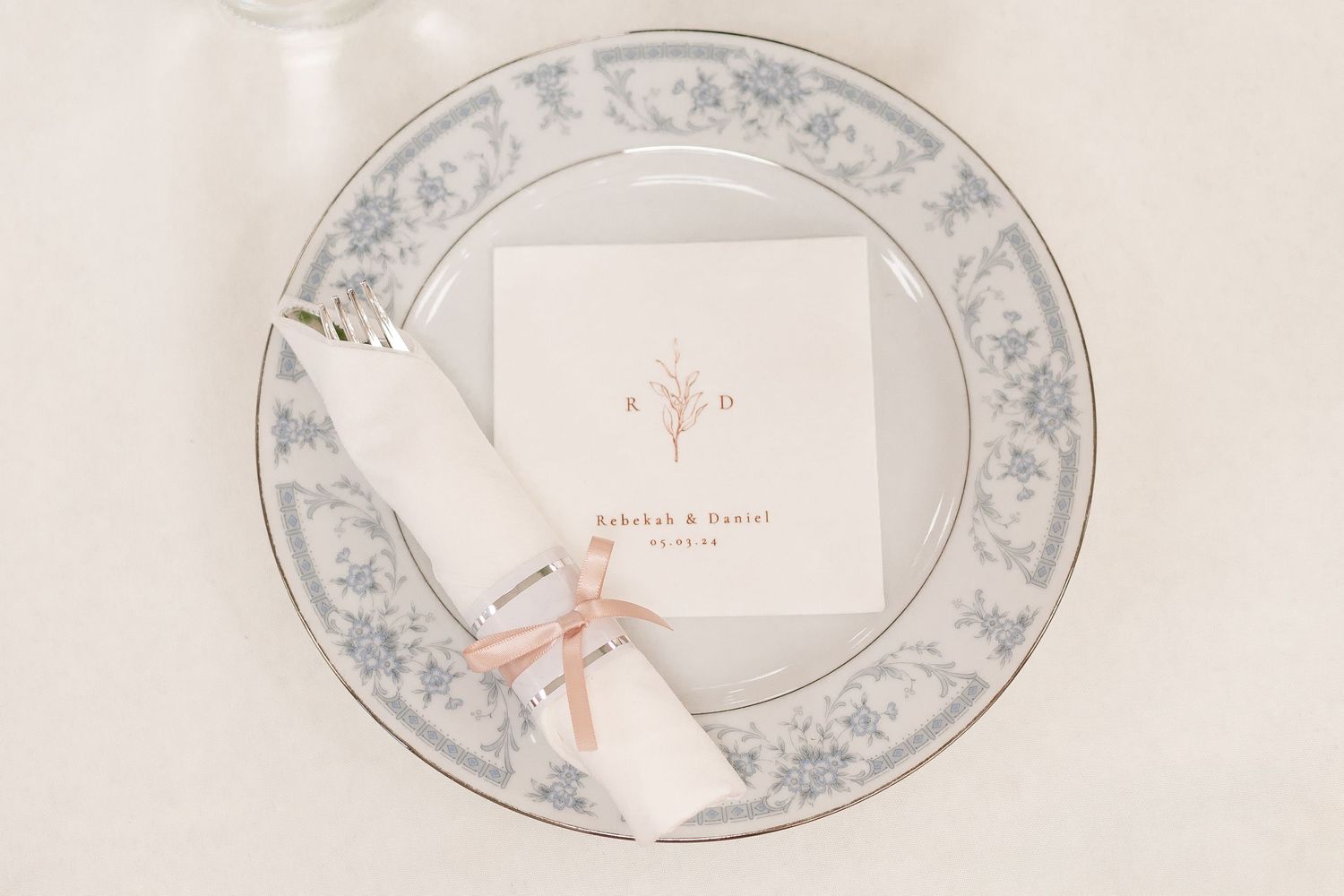 Fine china dinner plates with delicate blue floral pattern border displayed on cream background.