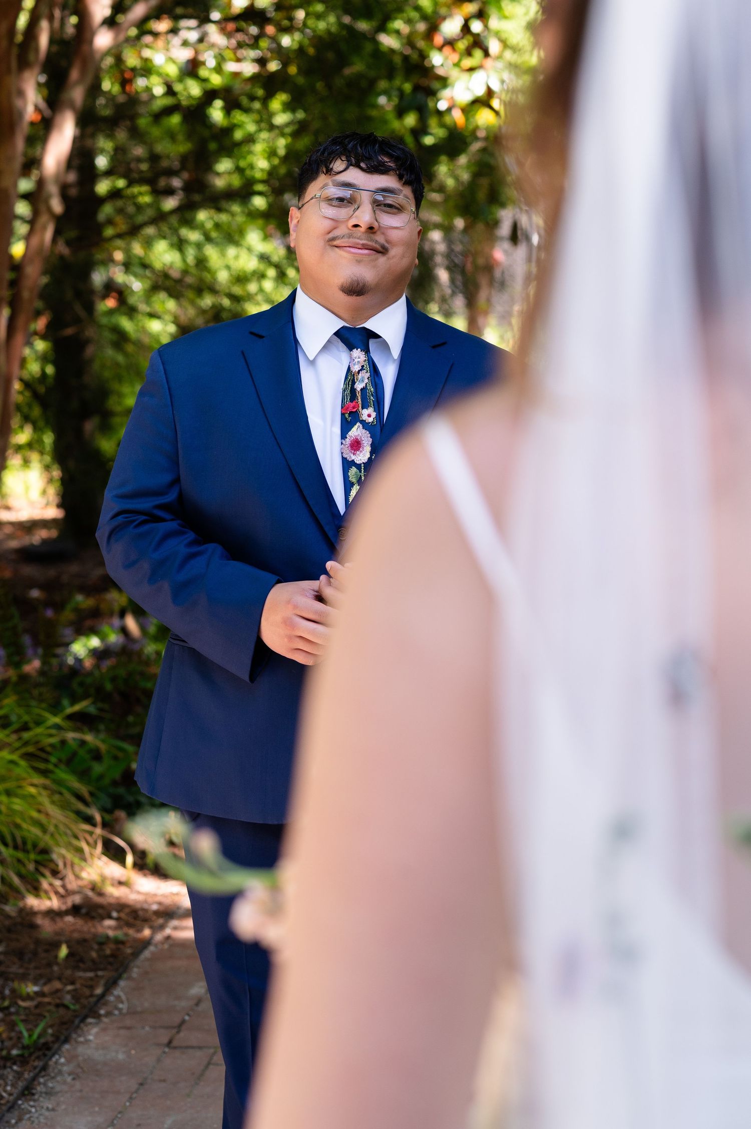 Wedding first look reaction captured in garden setting.