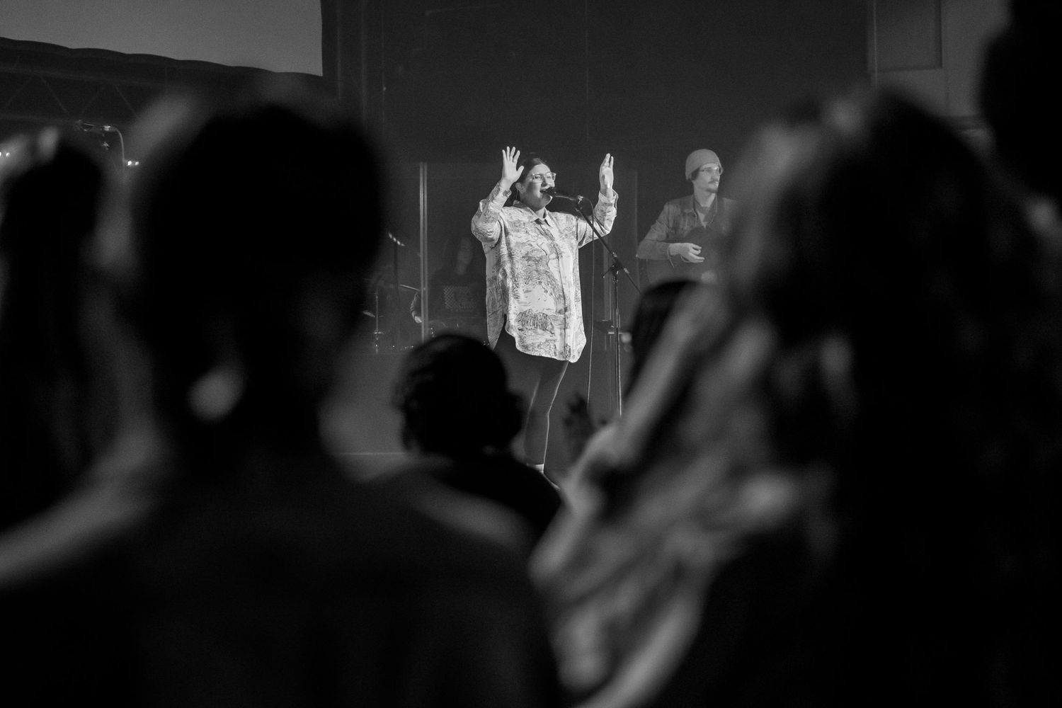 Black and white concert performance photos showing silhouettes of musicians and performers on stage with dramatic lighting.