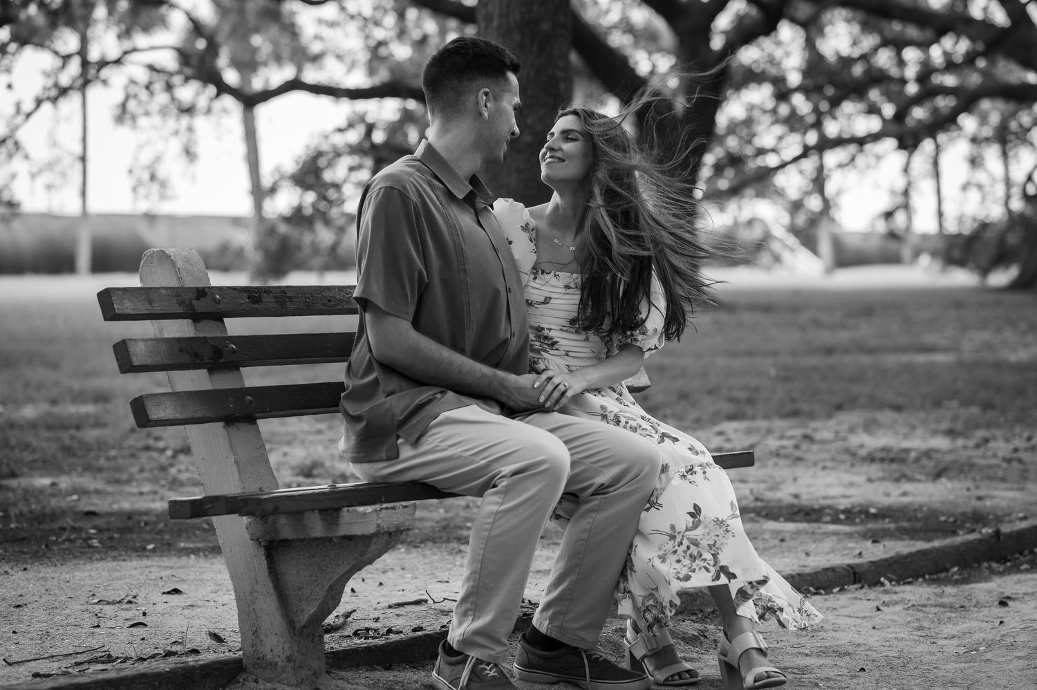 Couple sitting together on a wooden bench in a park setting.