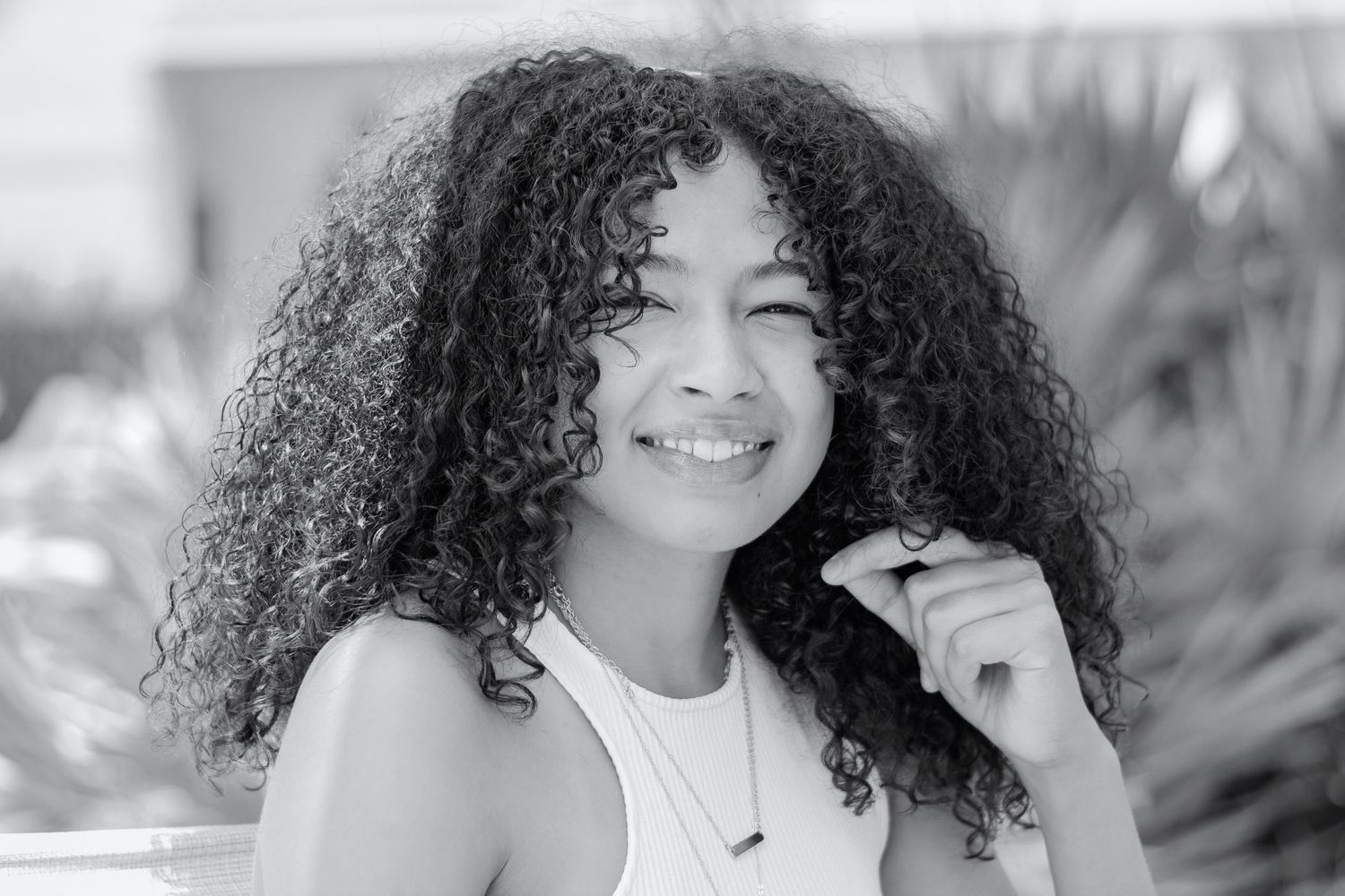 Outdoor portrait series showing natural curly hair and genuine smiles in sunlight.